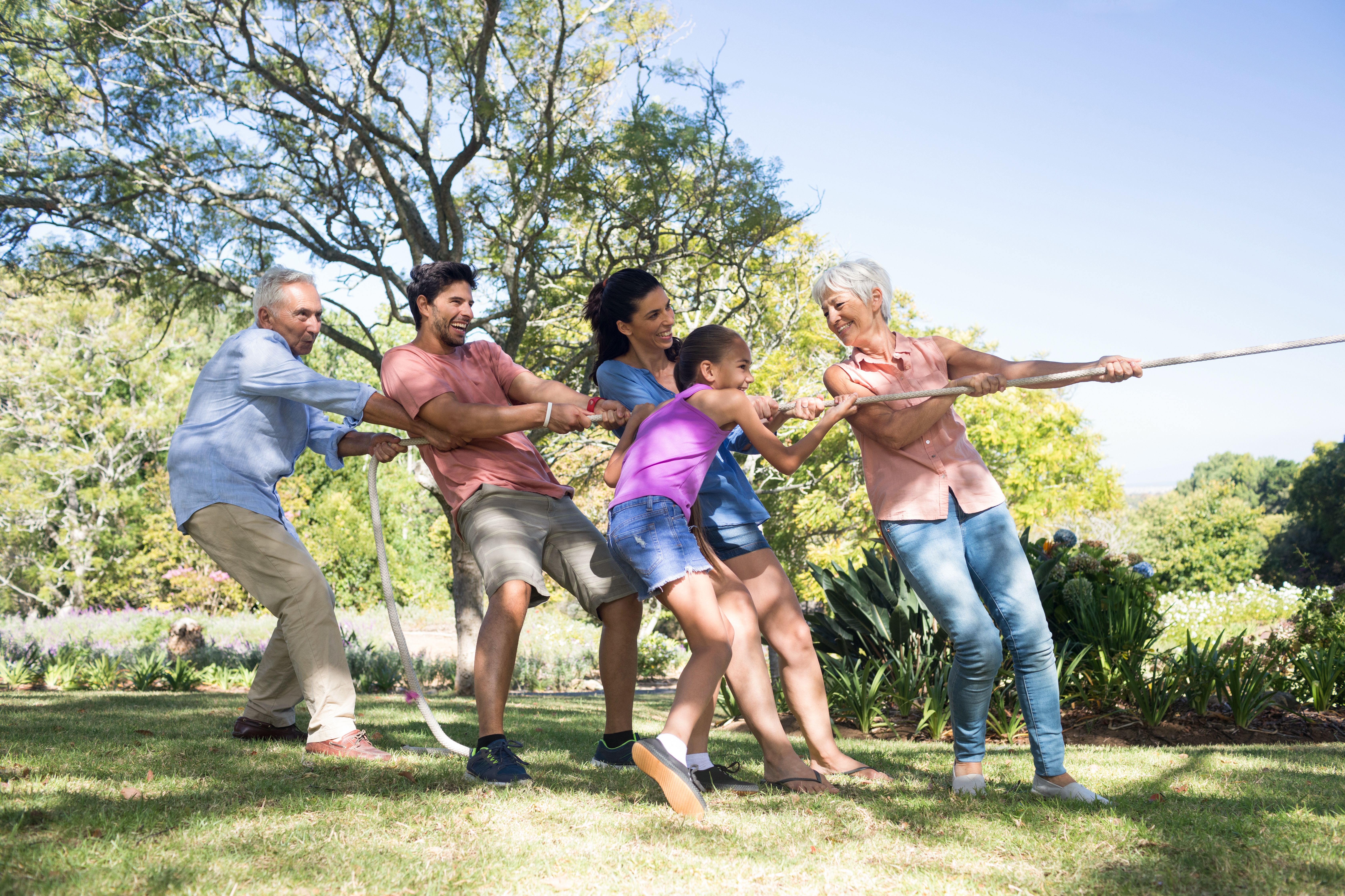 Five family members playing tug-of-war on a successfully planned family reunion.