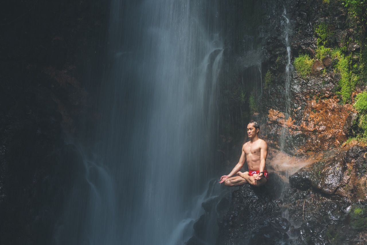 guy meditating in front of water at a silent retreat