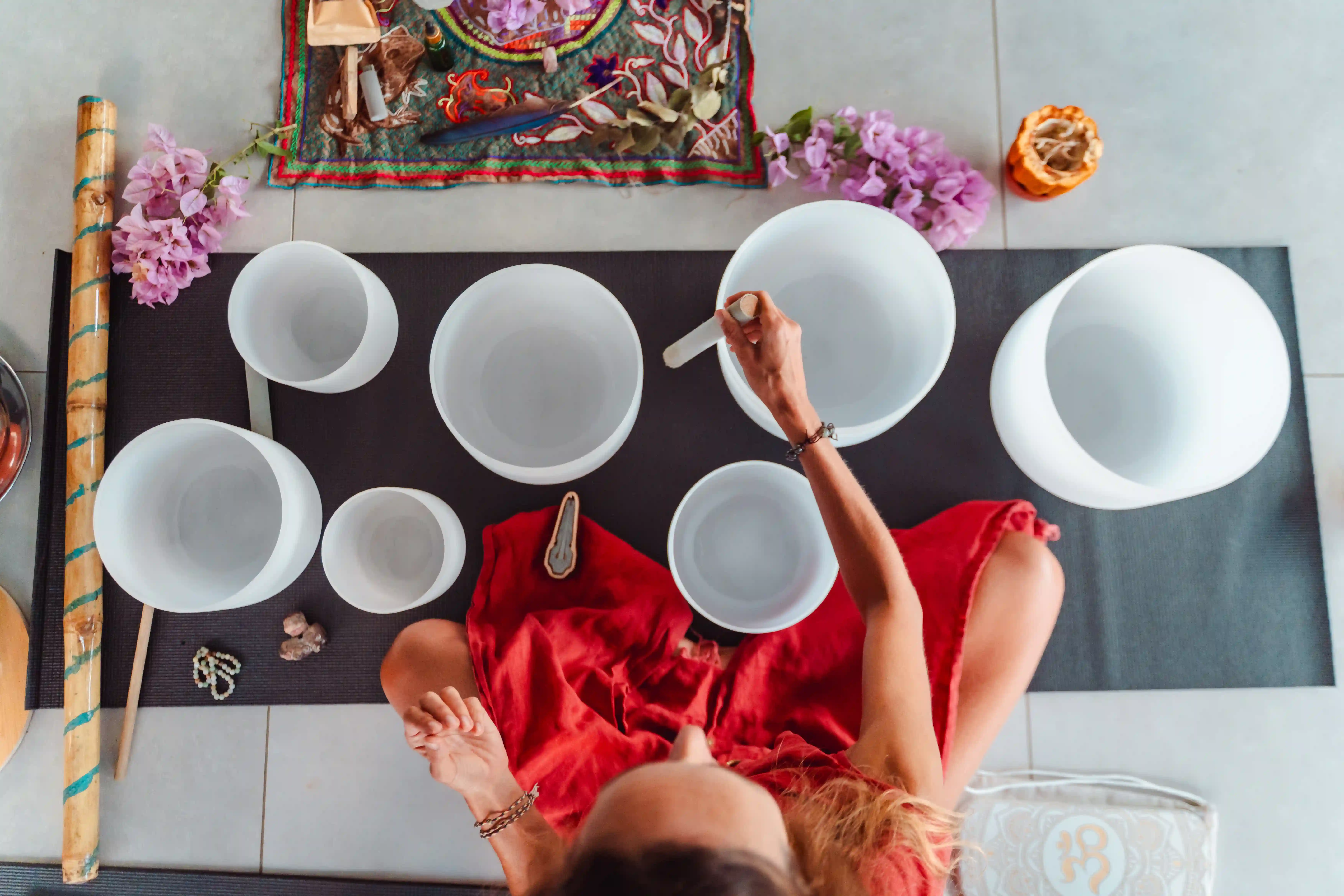 Sound healing practitioner playing crystal singing bowls at Vajra Jahra, creating a calming and restorative wellness experience.