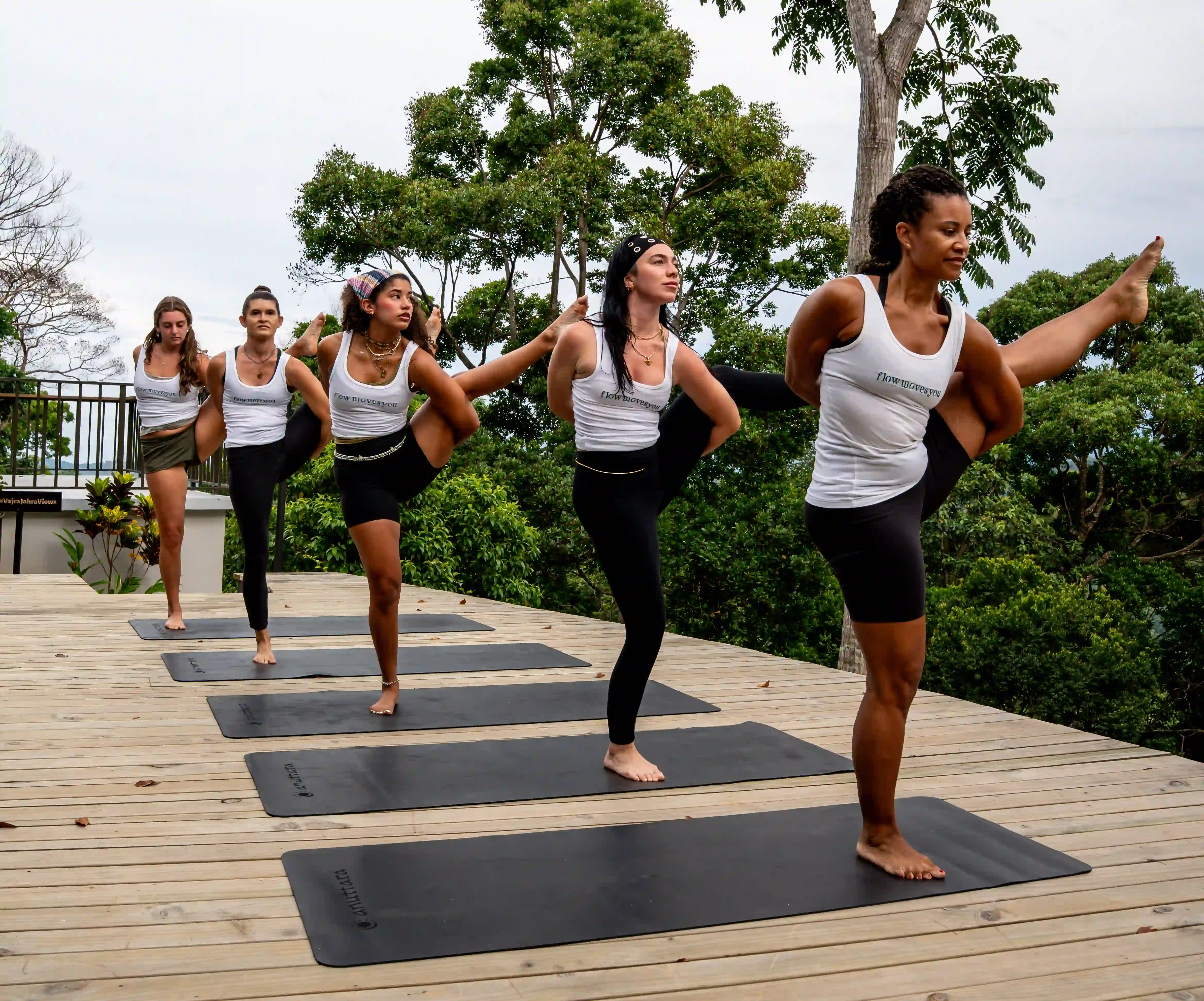 Group doing yoga on an outdoor wooden deck.