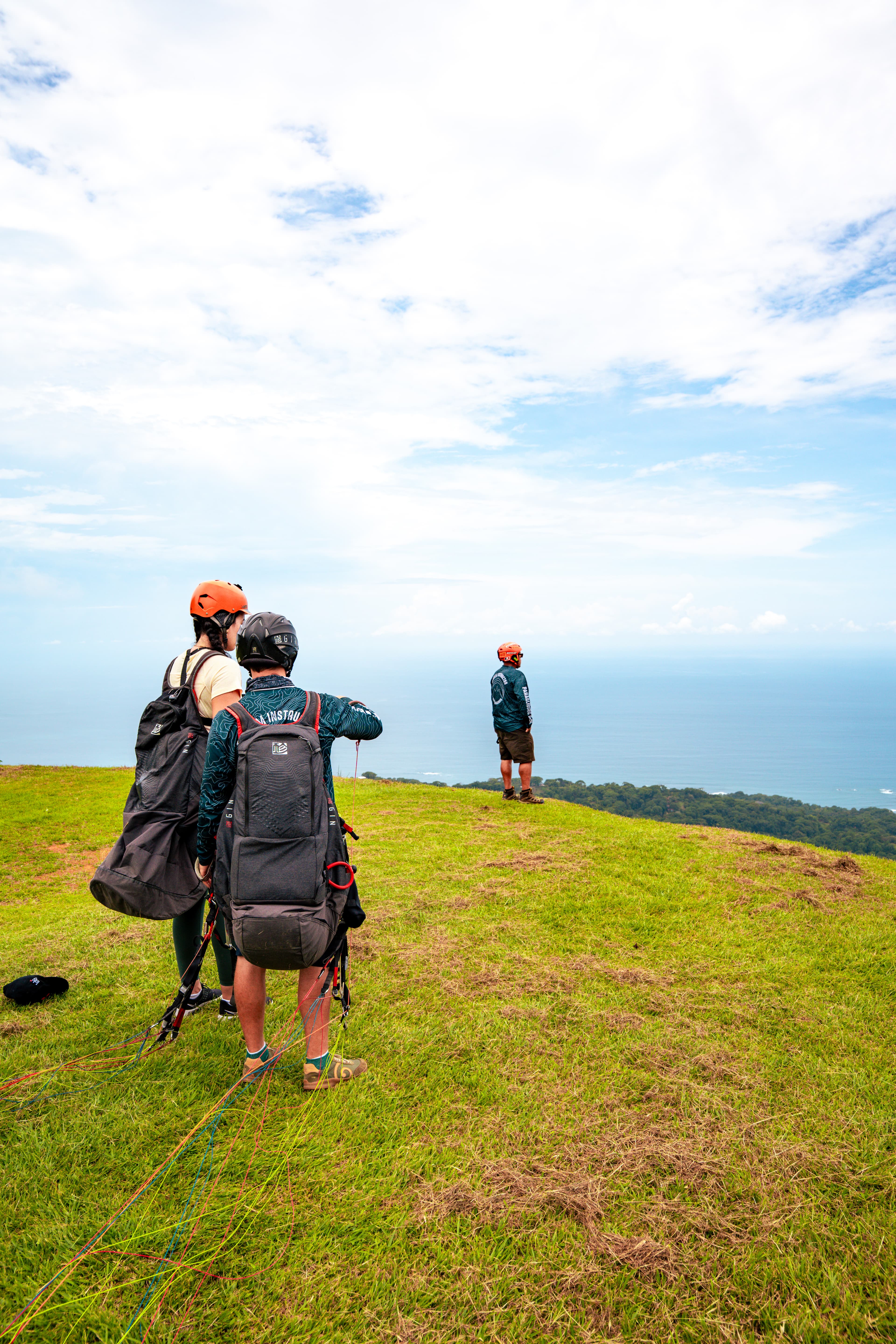 Setting up a paraglider on a grassy hill at sunrise, an adventurous add-on activity for guests at Vajra Jahra Retreat Center during their Yoga Retreat in Costa Rica.