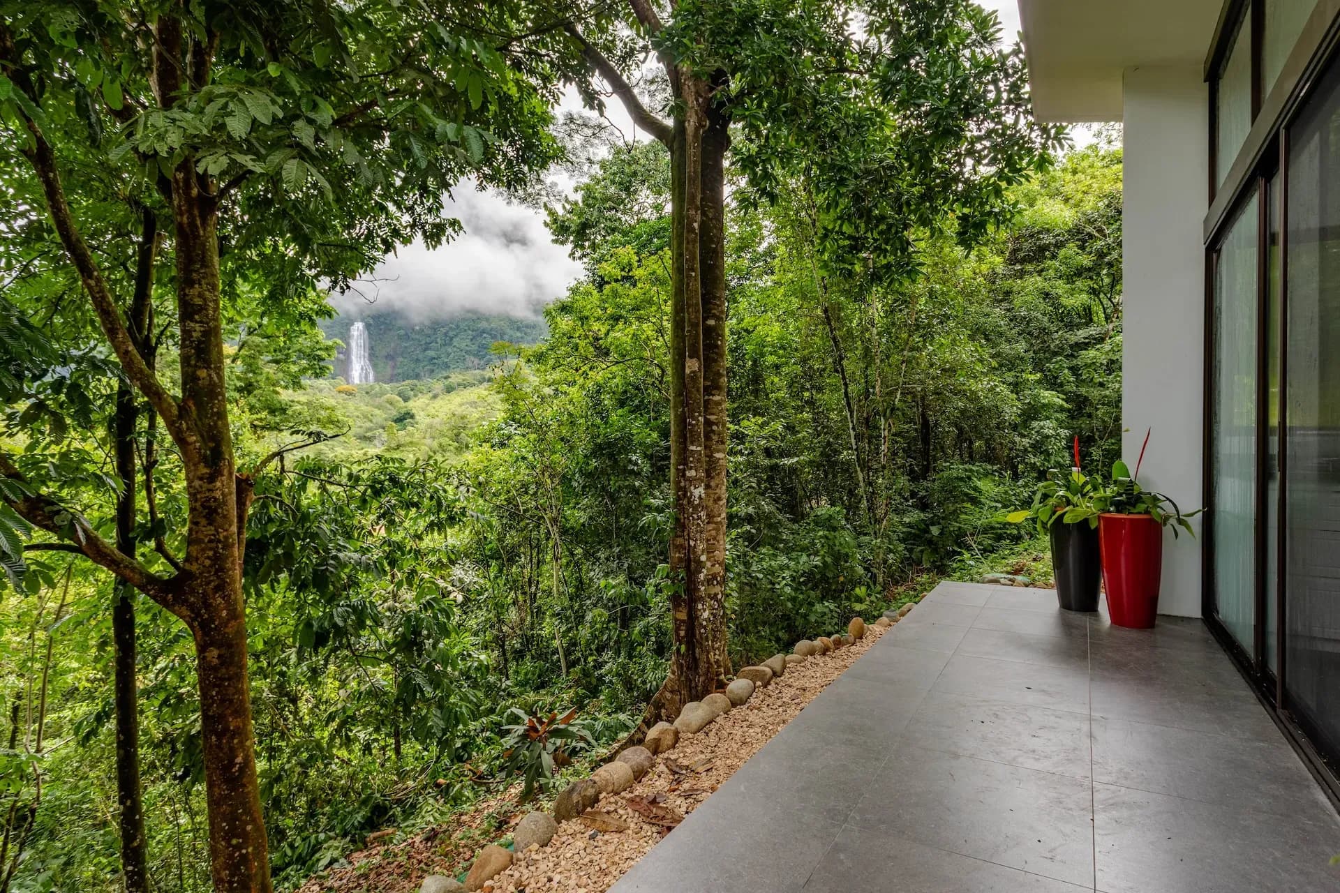 Waterfall view from private villa terrace at Vajra Jahra, a jungle retreat center in Costa Rica.