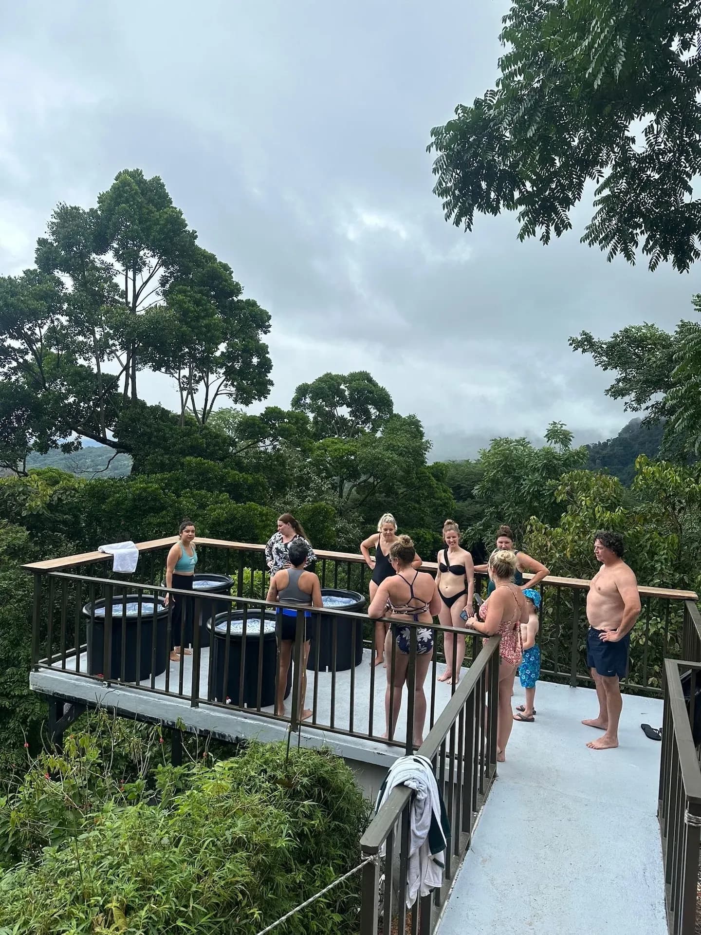Group enjoying cold plunge tubs on a jungle-view deck at a wellness retreat center in Costa Rica.
