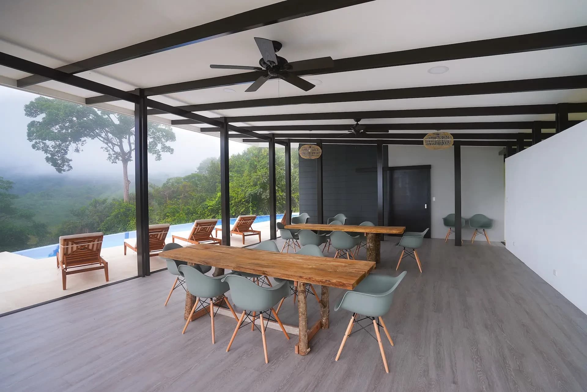 Open-air dining area at a Costa Rica retreat center with jungle views and infinity pool seating