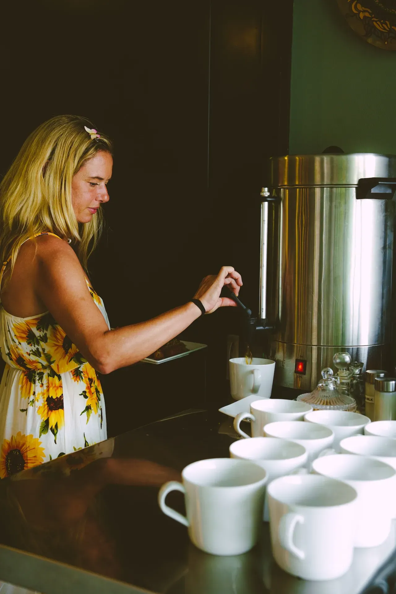 A woman serving herself coffee in Vajra Jahra's dining area.