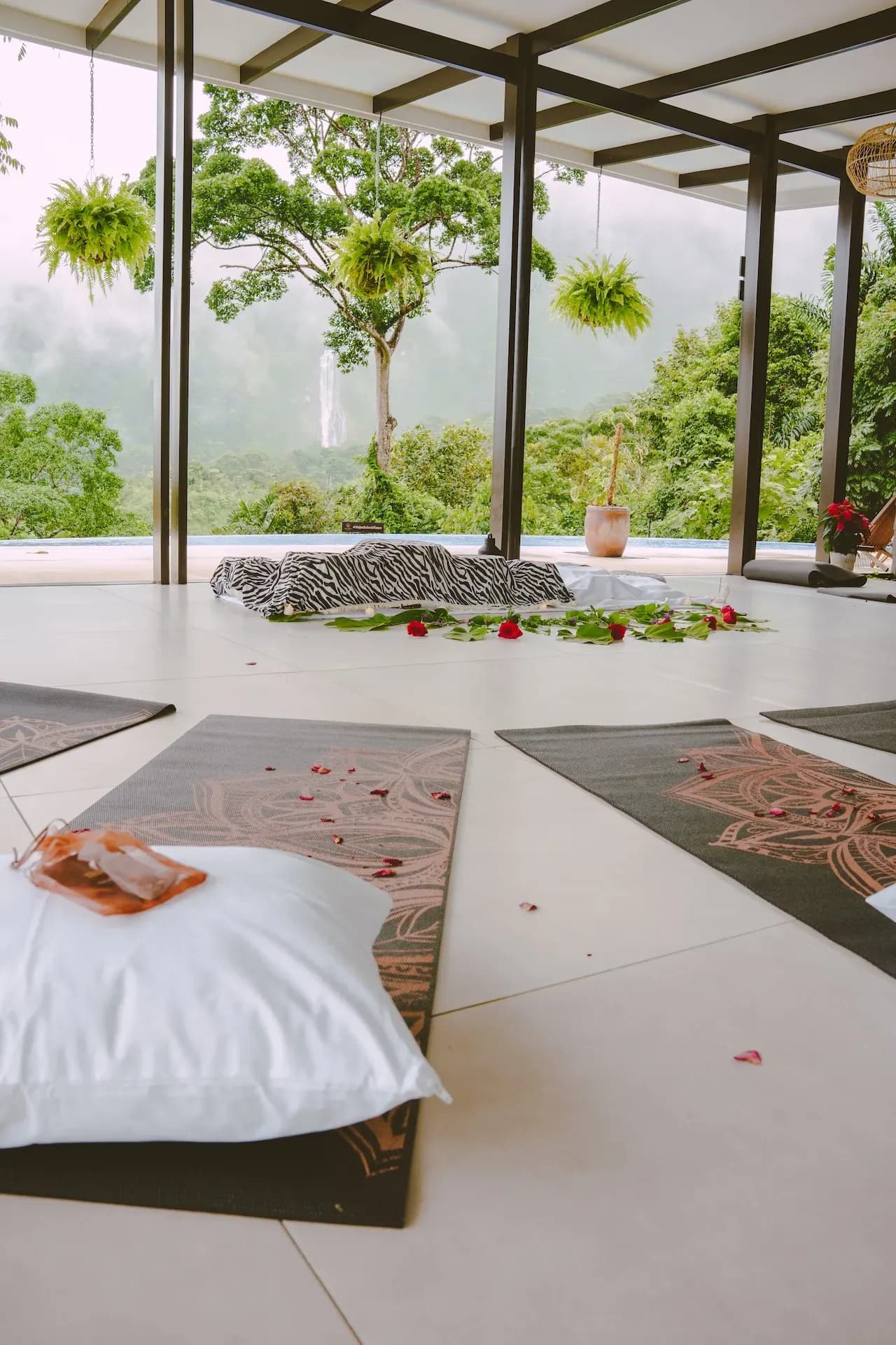 Yoga mats and sacred altar setup at a Costa Rica yoga retreat center with jungle and waterfall views.