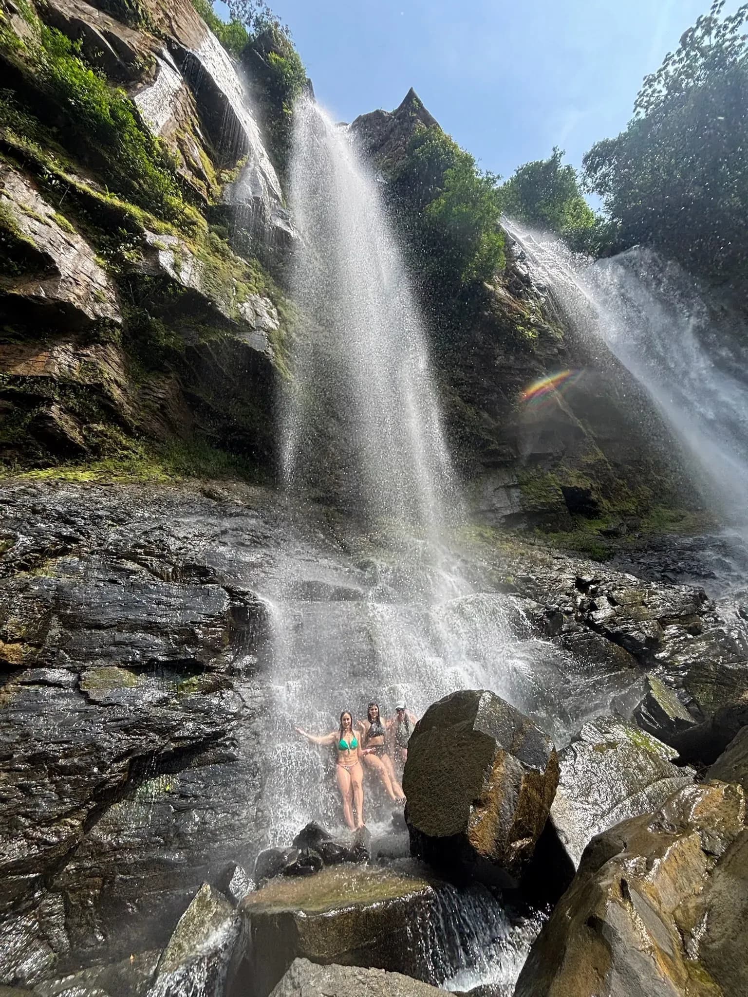 Retreat guests smiling under the falls in Costa Rica while on a trip to Nauyaca Waterfall.