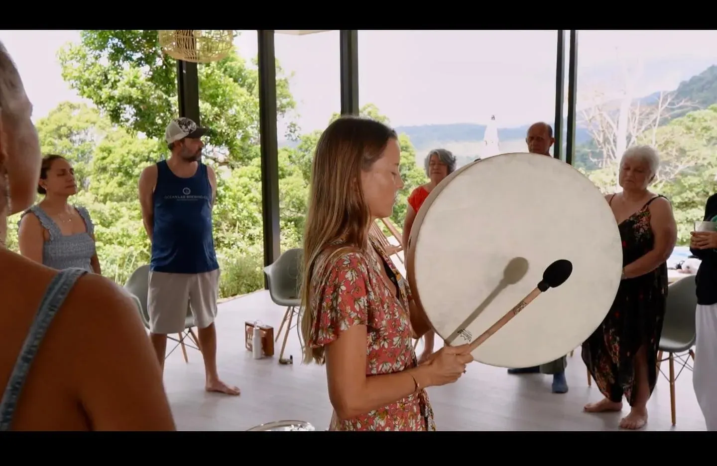 A guest with a drum leading a sound-based practice in Vajra Jahra's Costa Rica wellness retreat venue.