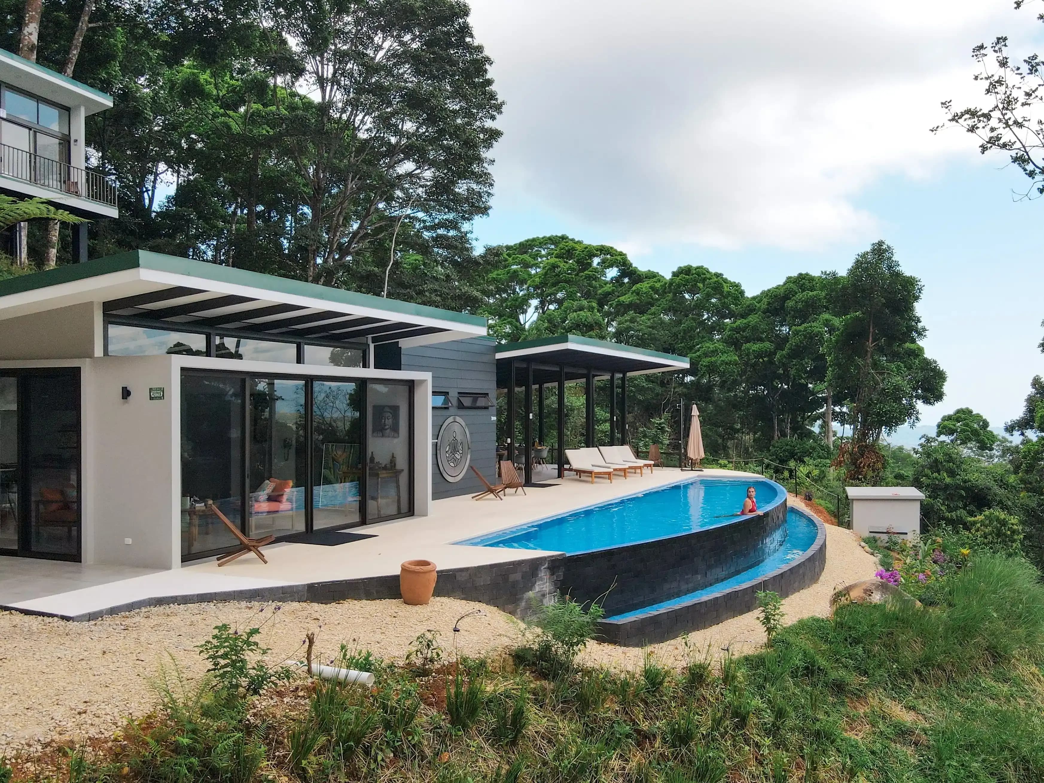 Infinity pool overlooking the jungle sits in front of the main gathering space, which includes the open-air event space and al fresco dining area—amenities included in our Costa Rica vacation rentals for large groups.