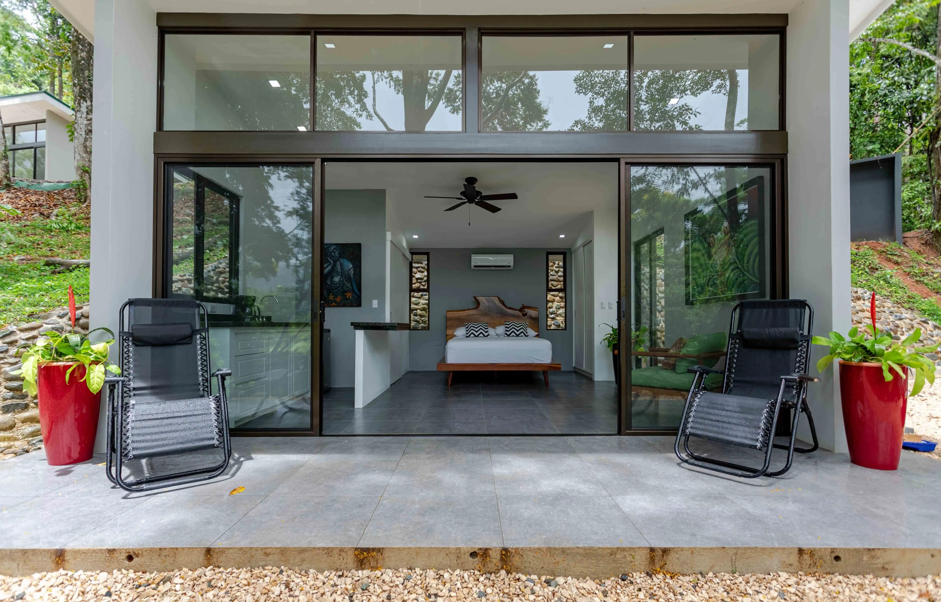 Exterior view of one of the villas, featuring a queen-sized bed, small kitchenette, and a private deck.