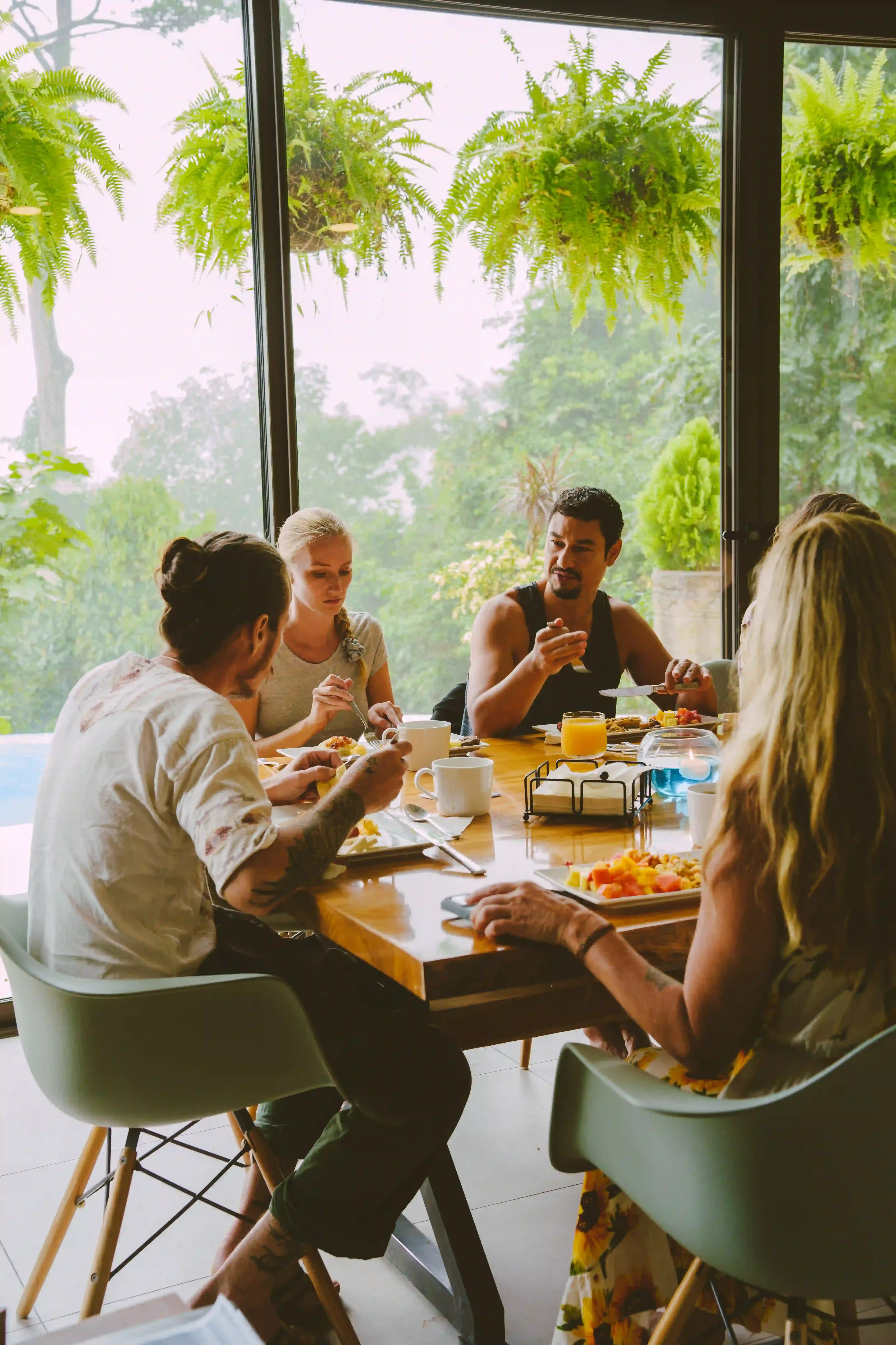 Guests sitting at the table enjoying locally sourced food in al fresco dining area.