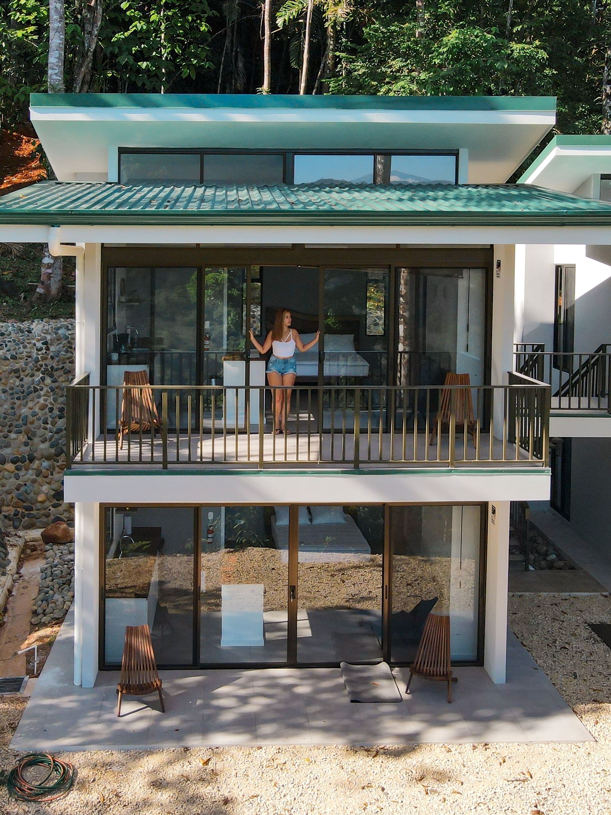 Exterior view of double villas with girl standing outside on the deck.
