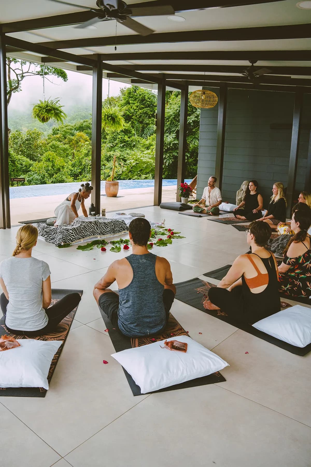 Open-air yoga shala with retreat guests practicing yoga.