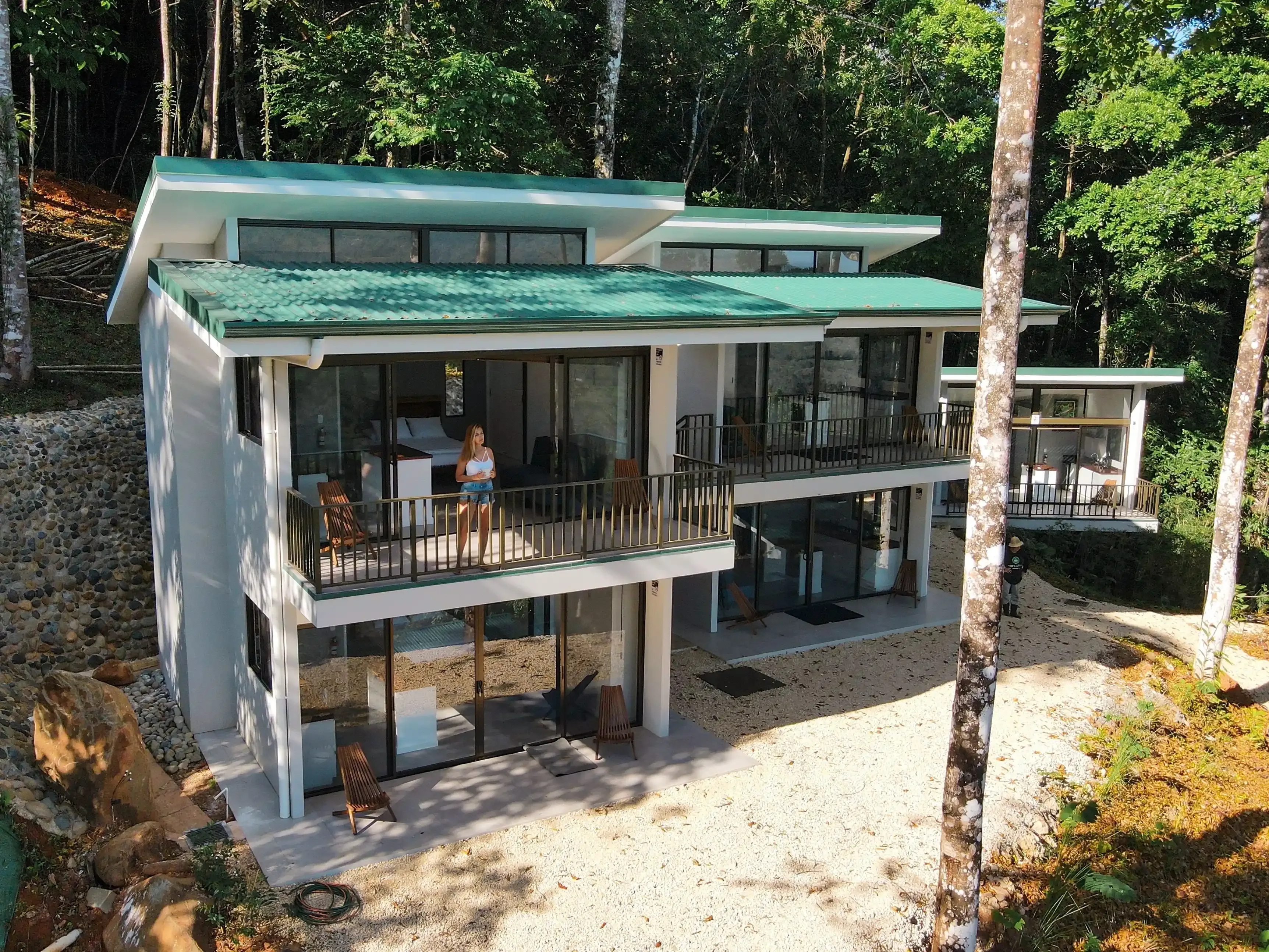 View of the villas at Vajra Jahra wellness retreat center in Costa Rica with a guest standing in one of the villa's private deck.