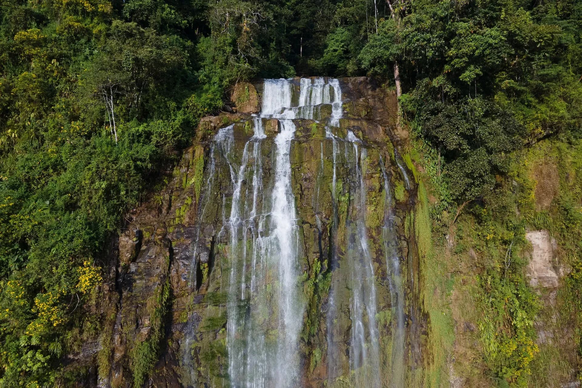 Majestic Diamante Waterfall cascading down mossy cliffs just minutes from Vajra Jahra, a nature-immersed Costa Rica Retreat Center.