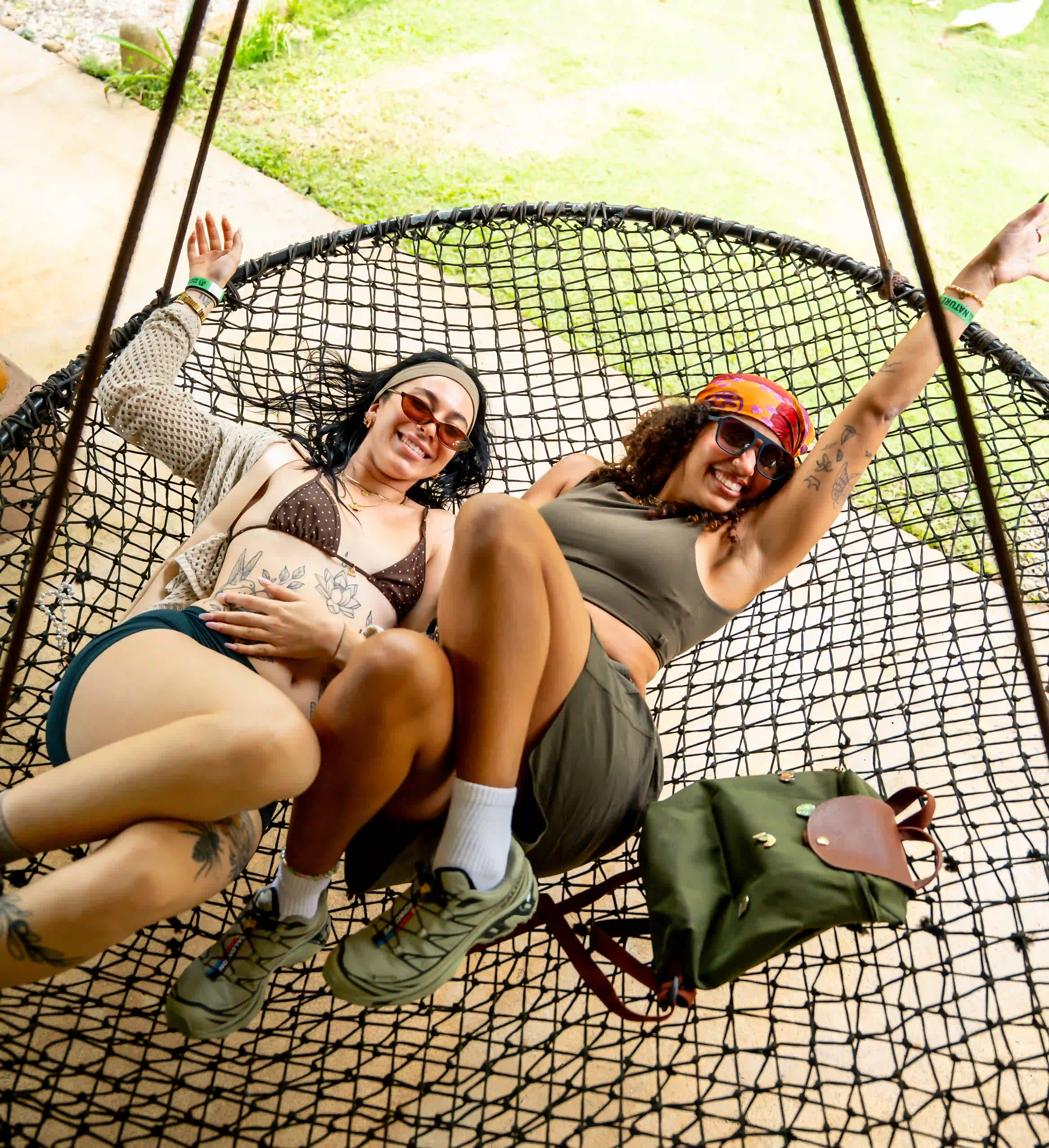 Guests relaxing on a woven daybed surrounded by lush greenery at Vajra Jahra, a wellness retreat center in Costa Rica.