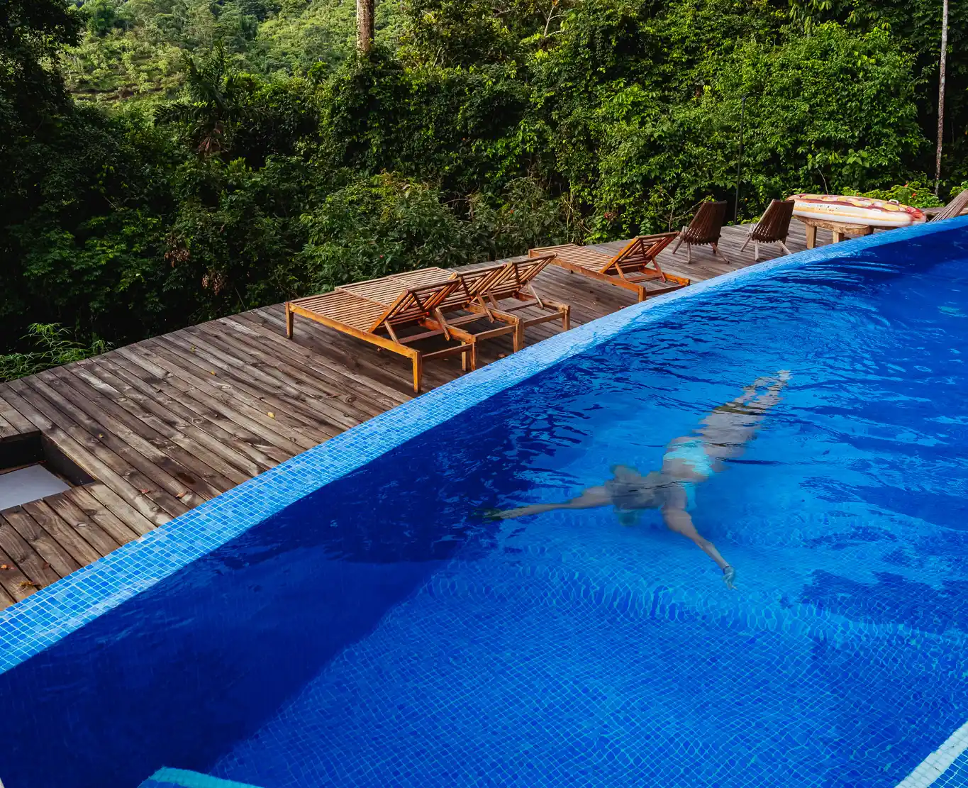 Guest floating peacefully in the infinity pool at Vajra Jahra, a luxury Costa Rica retreat center.