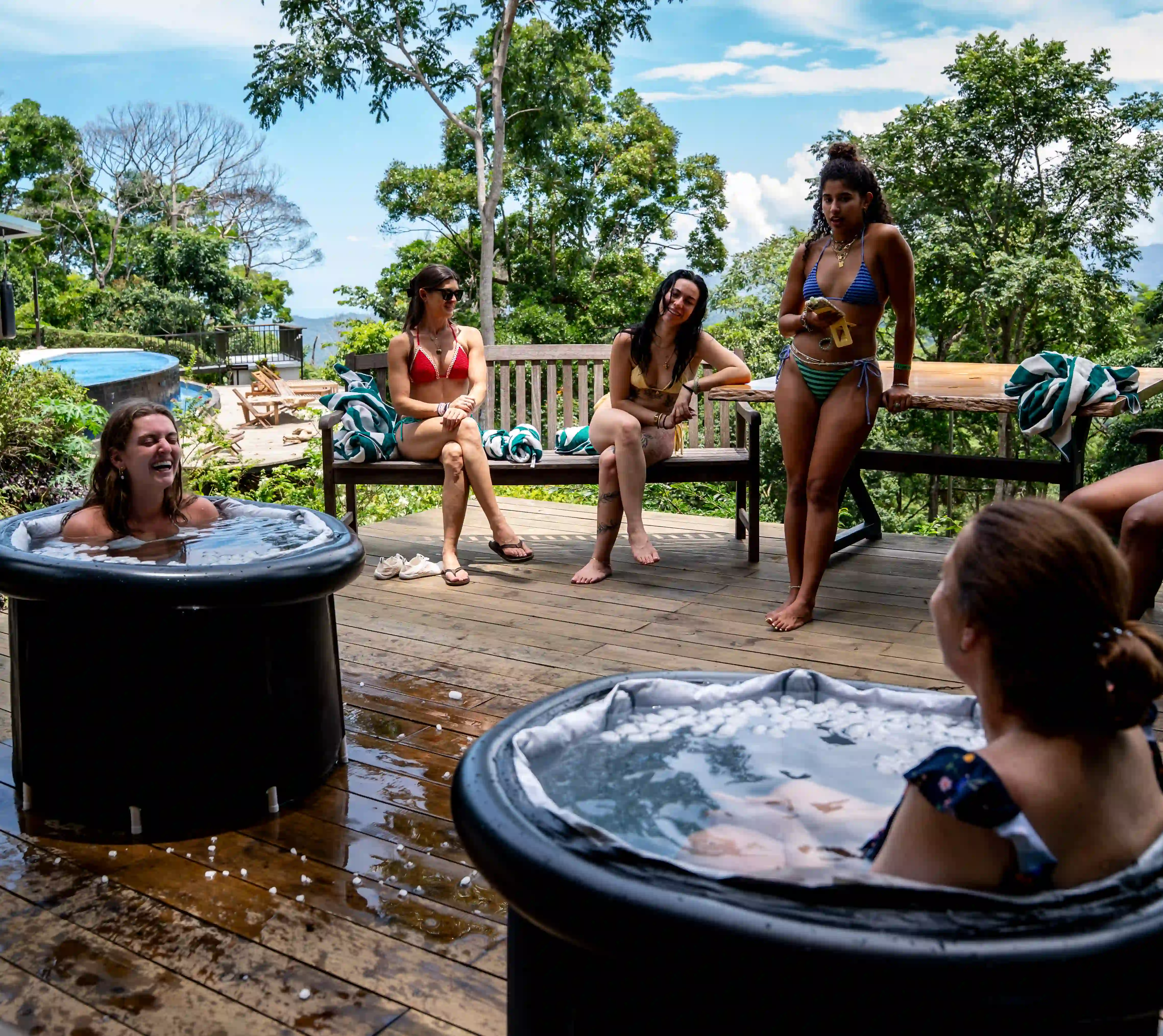 Two guests unwind in outdoor ice baths overlooking lush mountains near the Costa Rica Retreat Center, enjoying a refreshing wellness moment at Vajra Jahra.