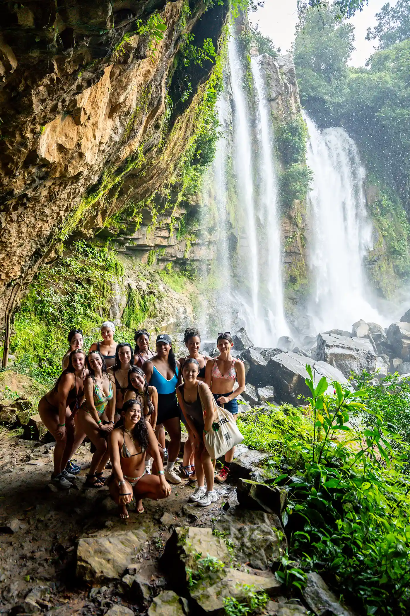 Guests from Vajra Jahra Costa Rica Retreat Center gathered while towering jungle waterfalls.