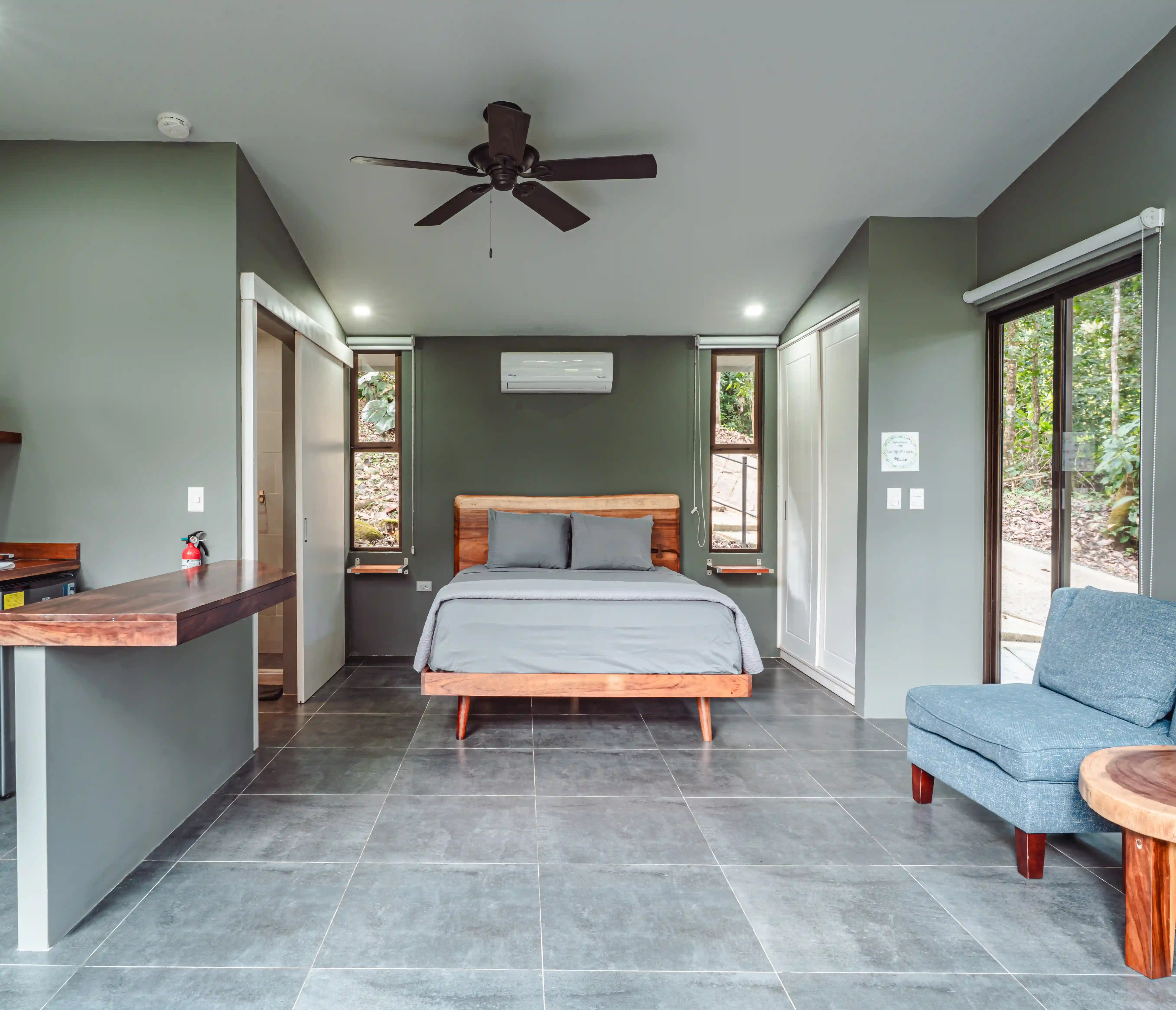 Exterior view of a one-bedroom villa with open glass doors and a relaxing bedroom view at Vajra Jahra, a Costa Rica Retreat Center offering serene private accommodations.