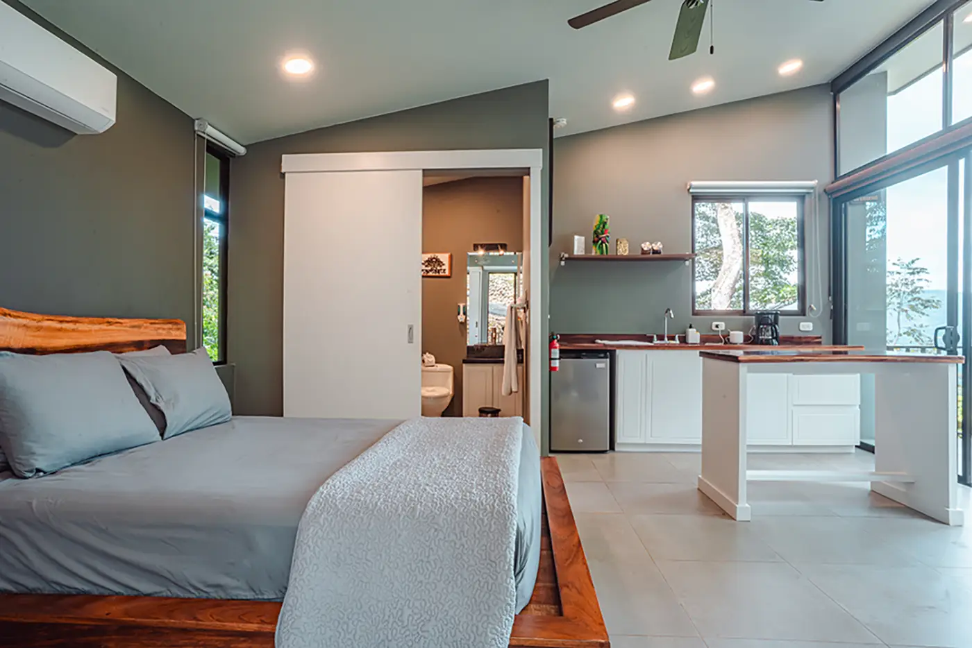 Comfortable bedroom with a kitchenette at Vajra Jahra, offering a peaceful stay at the Wellness Retreat Center in Costa Rica.