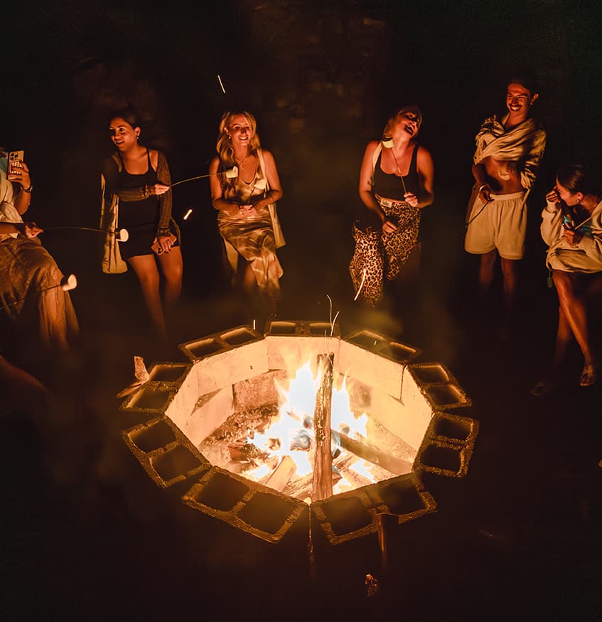 Guests gathered around a nighttime bonfire at Vajra Jahra, embracing connection and community during the retreat experience.