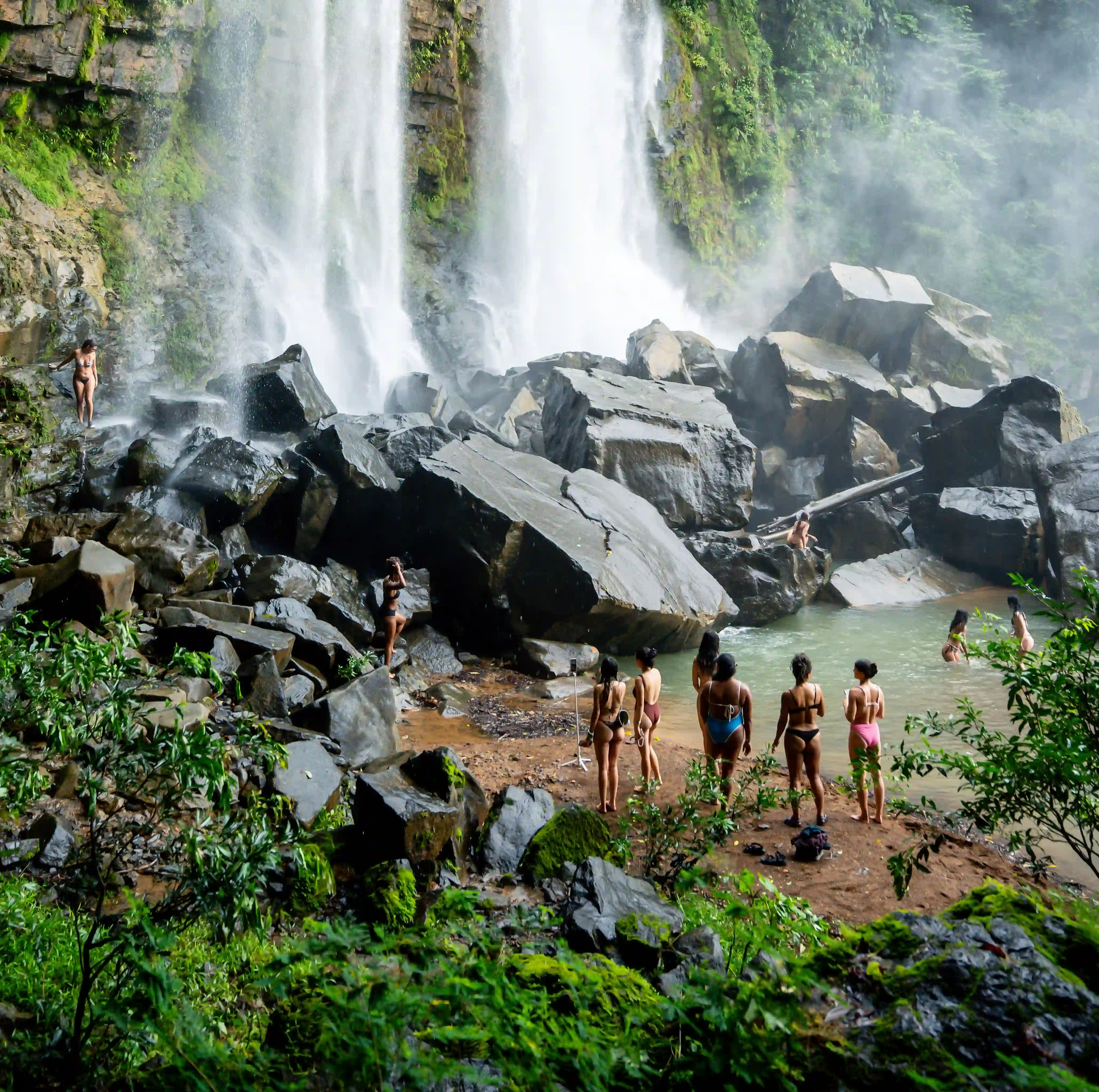 Guests enjoying a natural waterfall pool close to Vajra Jahra Retreat Center, a scenic adventure included in a Yoga Retreat in Costa Rica.