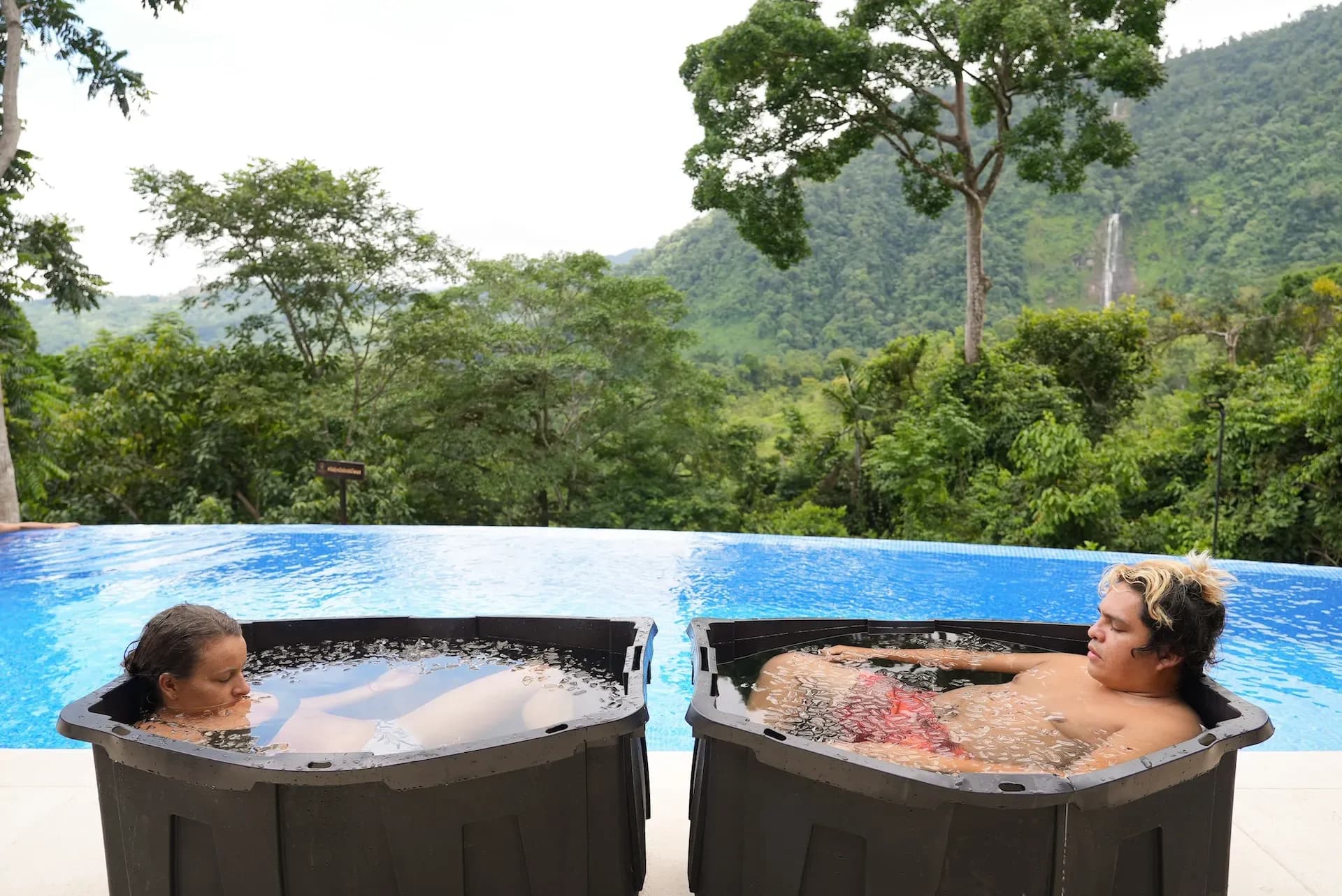 Two guests unwind in outdoor ice baths overlooking lush mountains near the Costa Rica Retreat Center, enjoying a refreshing wellness moment at Vajra Jahra.