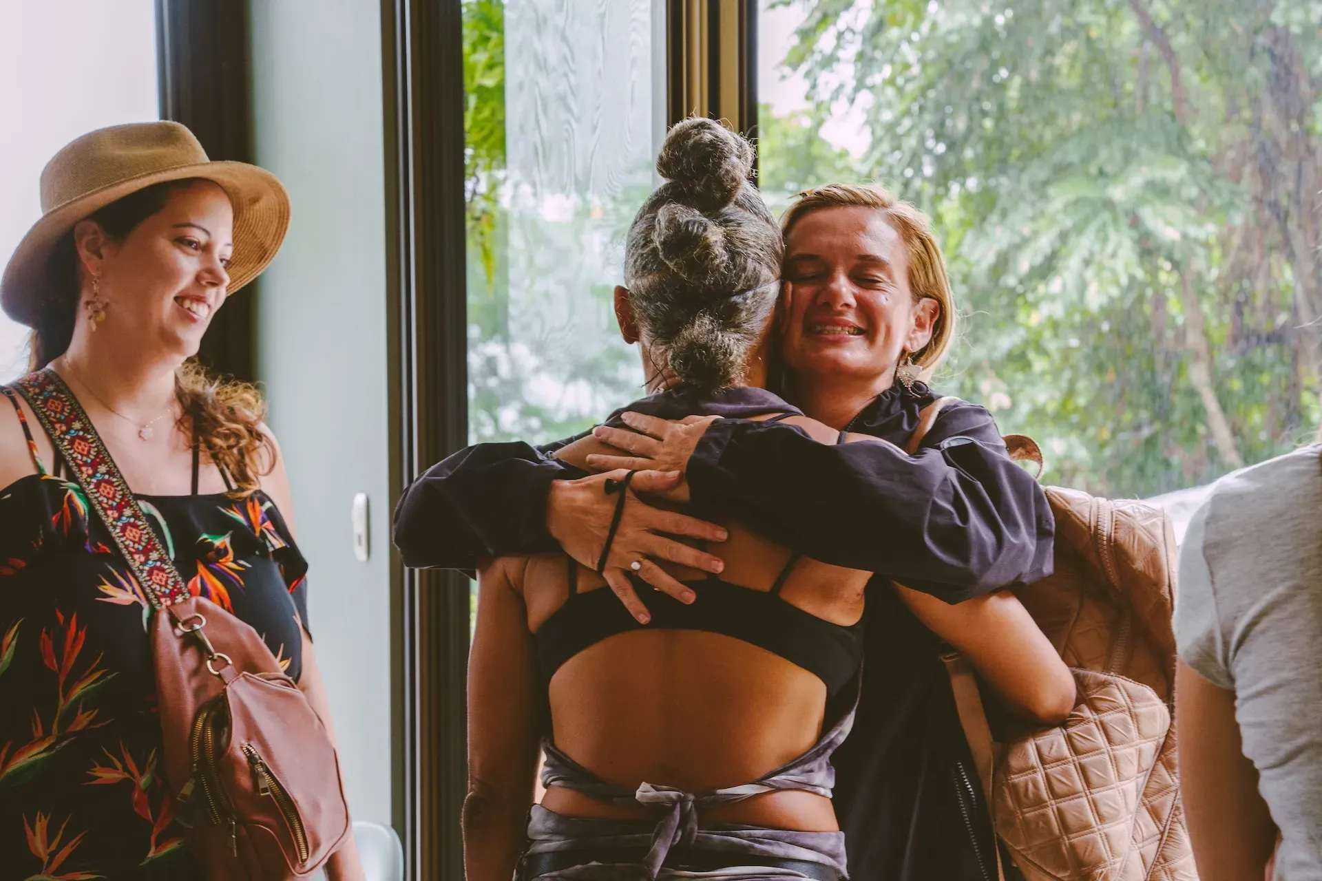 Retreat guests greeting each other with warm embraces inside Vajra Jahra, a vibrant community space at a leading Costa Rica Retreat Center.