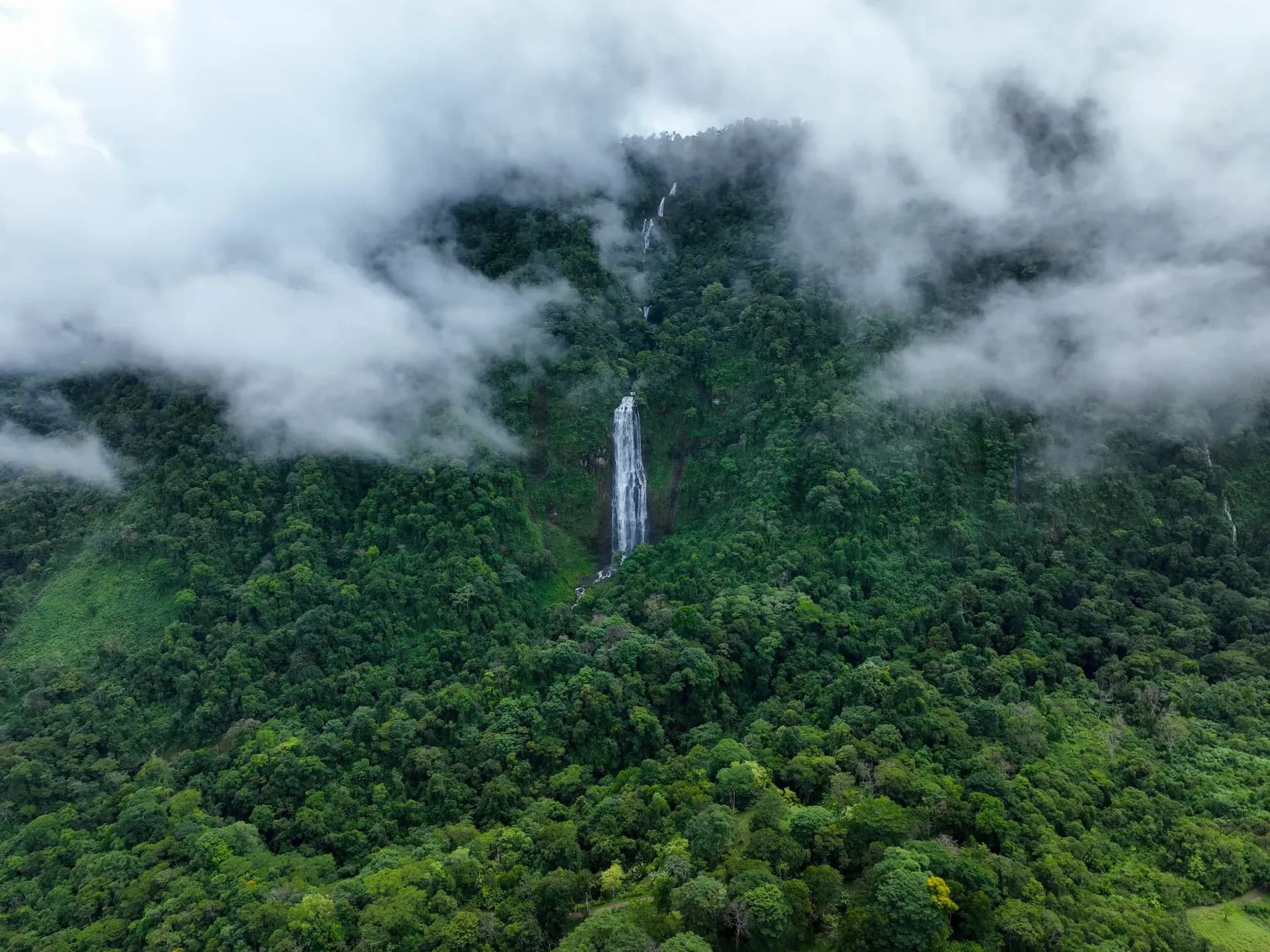 Aerial view of the Diamante waterfall overlooking Vajra Jahra, a serene Costa Rica Retreat Center surrounded by lush nature.