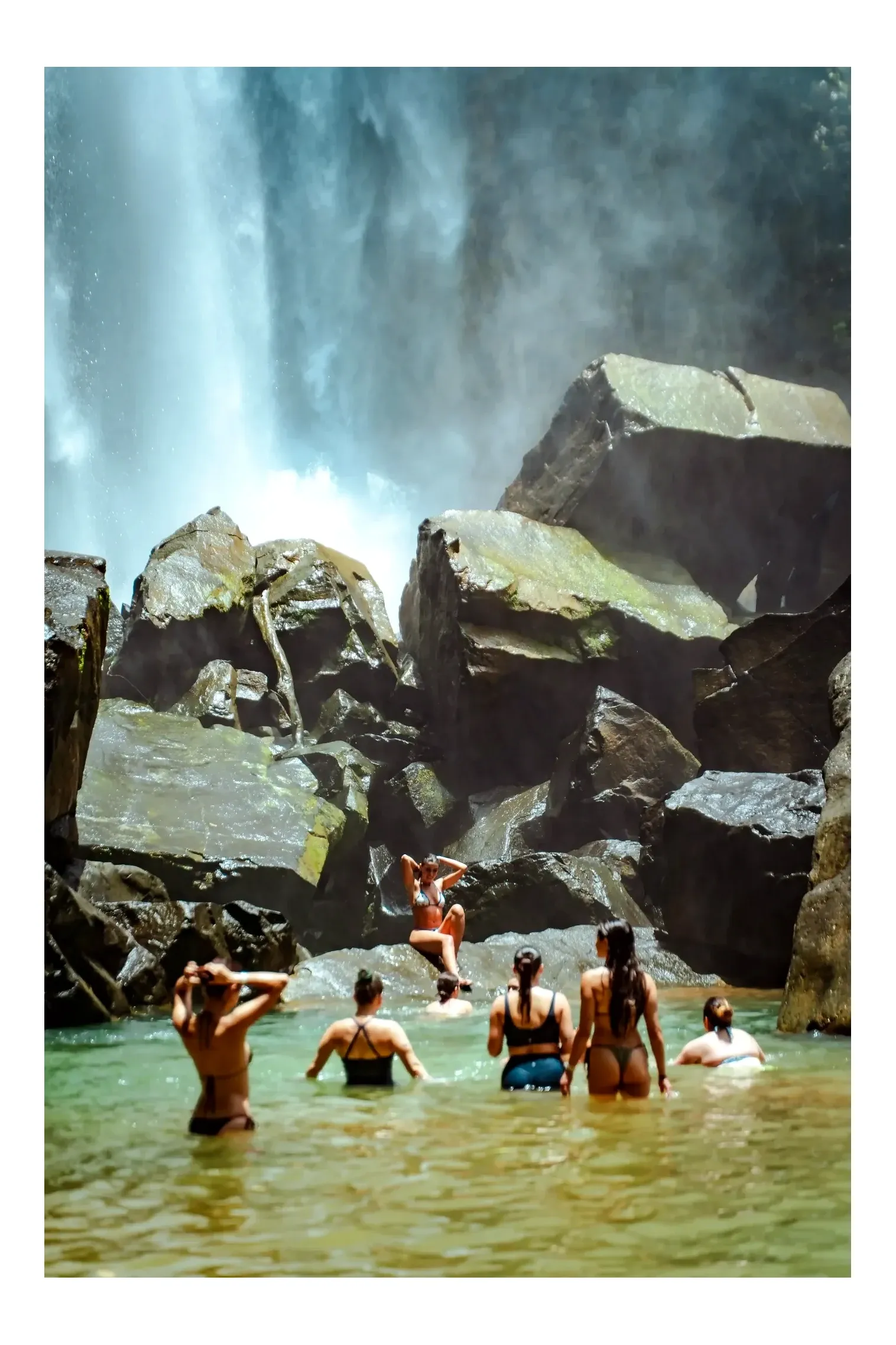 Guests from the Costa Rica retreat center Vajra Jahra swimming at a waterfall and enjoying a natural pool.