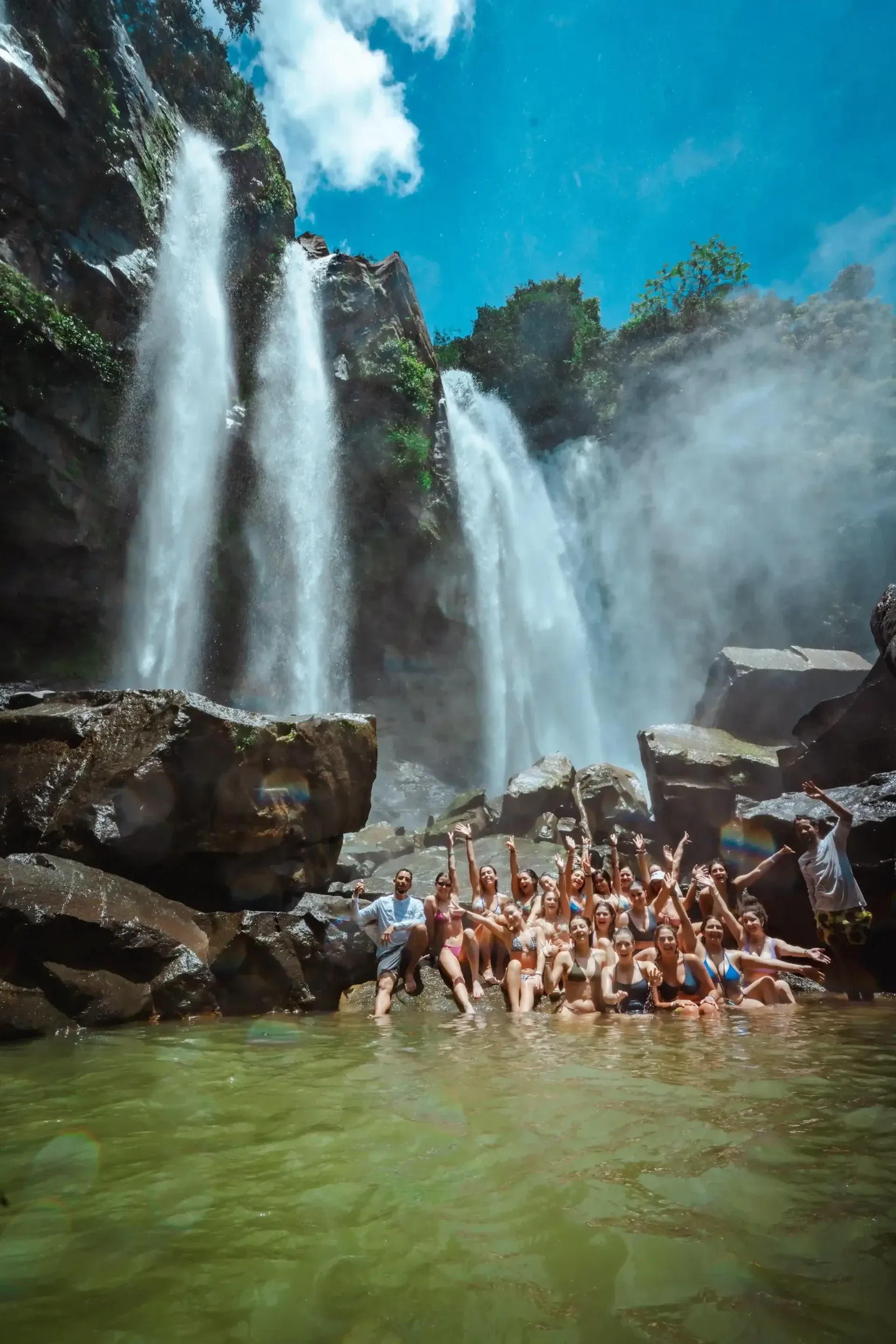 Guests from Vajra Jahra Costa Rica Retreat Center gathered in the natural pool beneath towering jungle waterfalls.