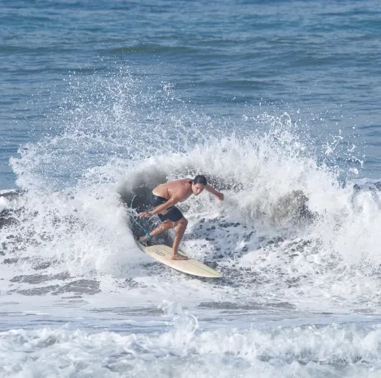 A surfer carves sharply through a wave near the Costa Rica Retreat Center, showcasing the adventurous coastal energy surrounding Vajra Jahra.