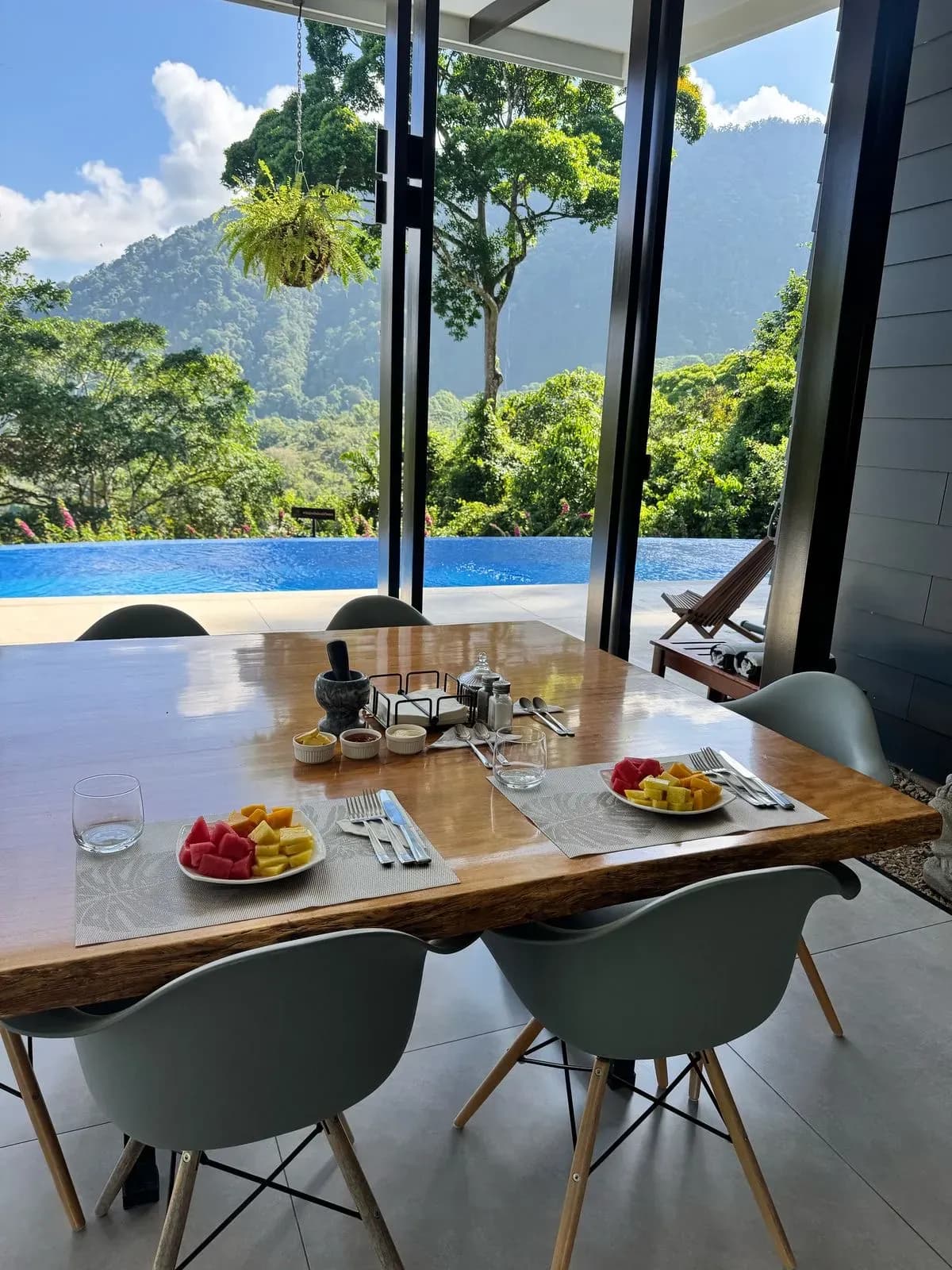 Fresh fruit breakfast with mountain and pool views at a jungle retreat center in Costa Rica.