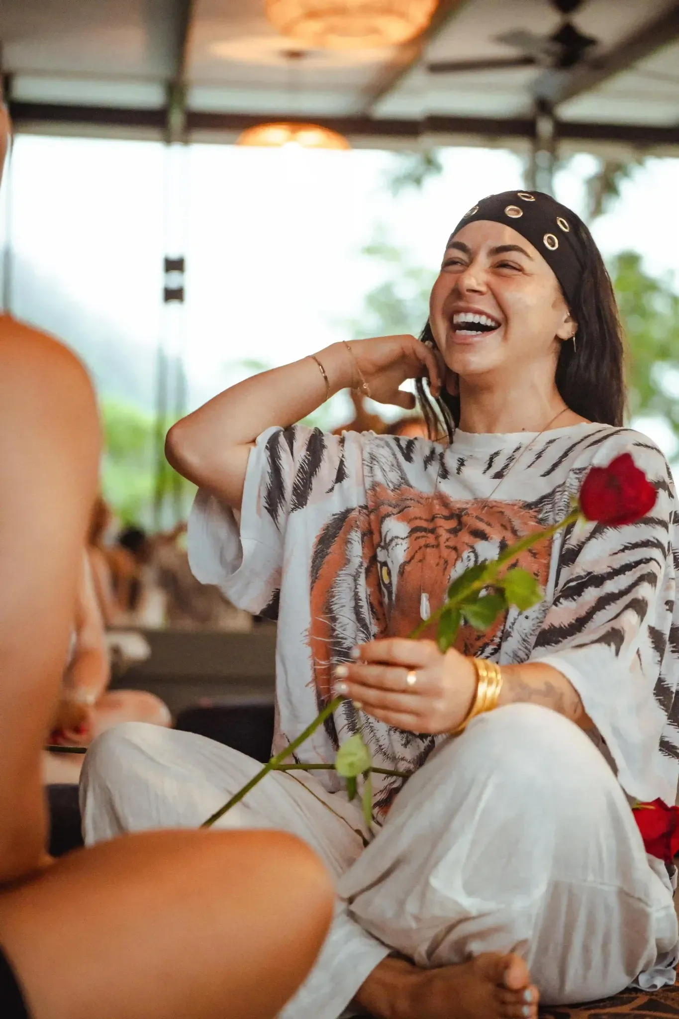 Smiling woman holding a rose during a group session at Vajra Jahra Retreat Center, highlighting connection and joy in Airbnb vacation packages.