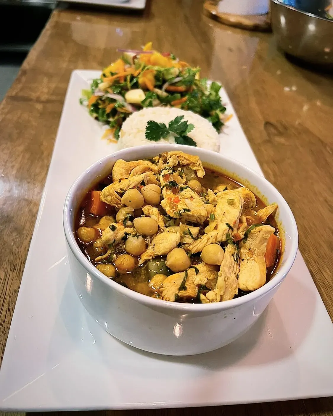A warm chickpea and vegetable bowl served with a fresh salad at a Costa Rica Retreat Center, showcasing the wholesome meals crafted at Vajra Jahra.