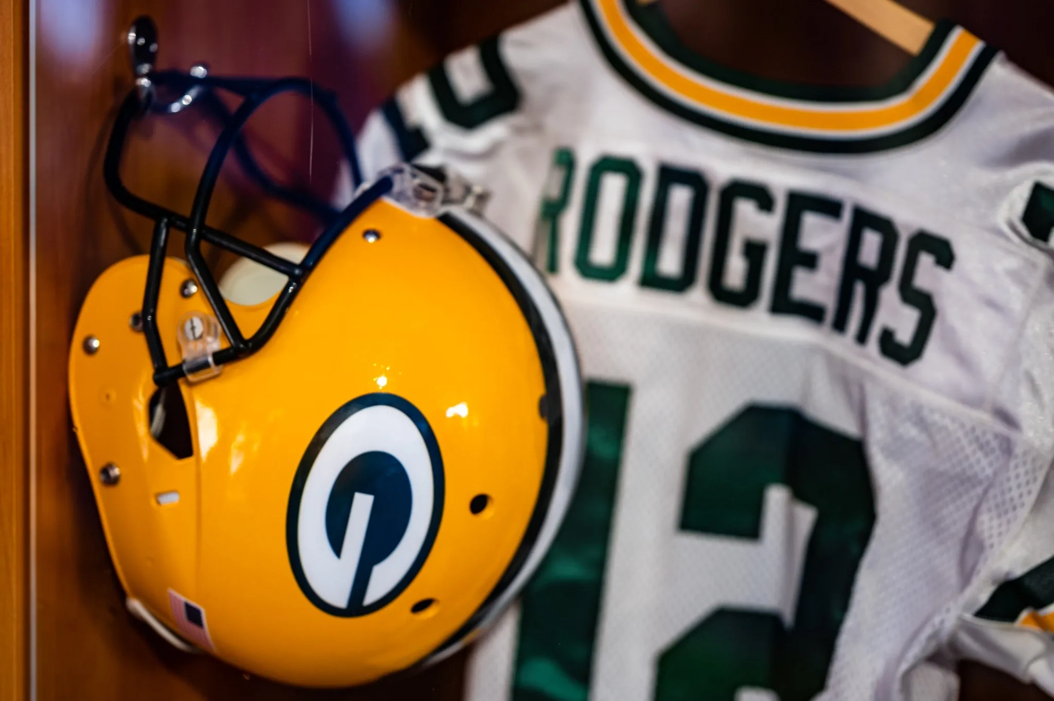 Aaron Rodgers' Green Bay Packers helmet and #12 jersey hung up on display.