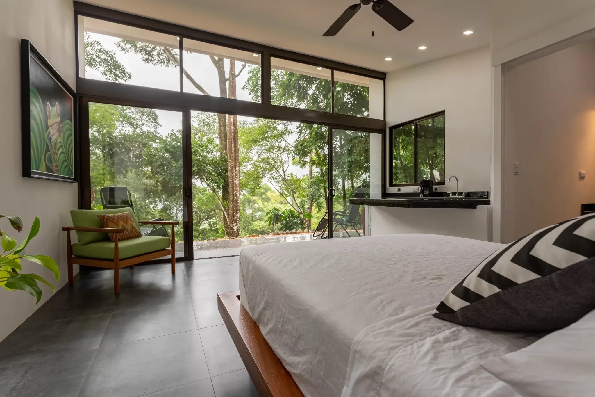 Minimalist bedroom design overlooking lush greenery at Vajra Jahra Retreat Center, showcasing upscale comfort beyond what most Airbnb Dominical Costa Rica listings offer.