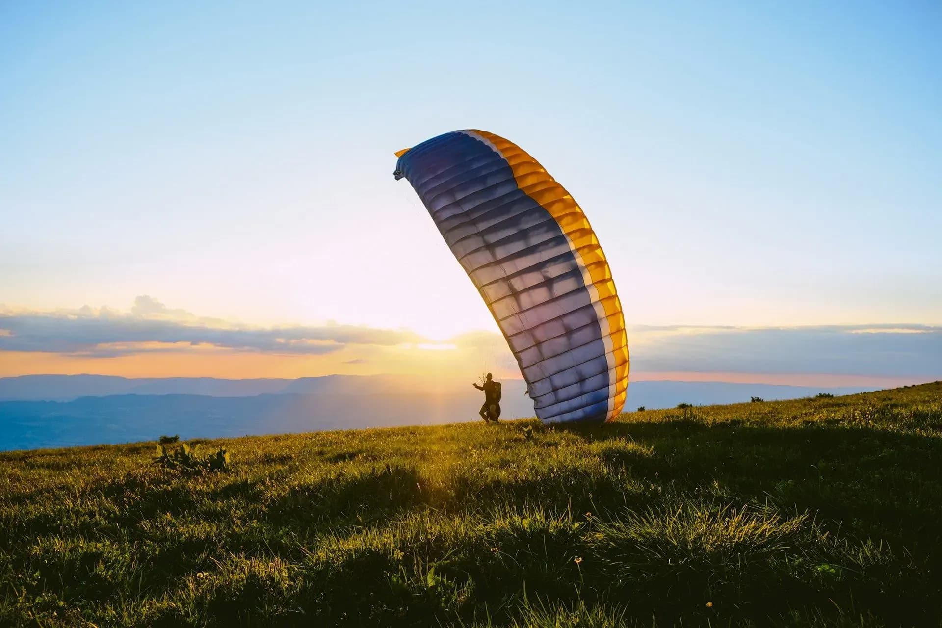 Paraglider launching at sunrise near Vajra Jahra Retreat Center, a scenic destination for adventurers looking to rent a retreat center.
