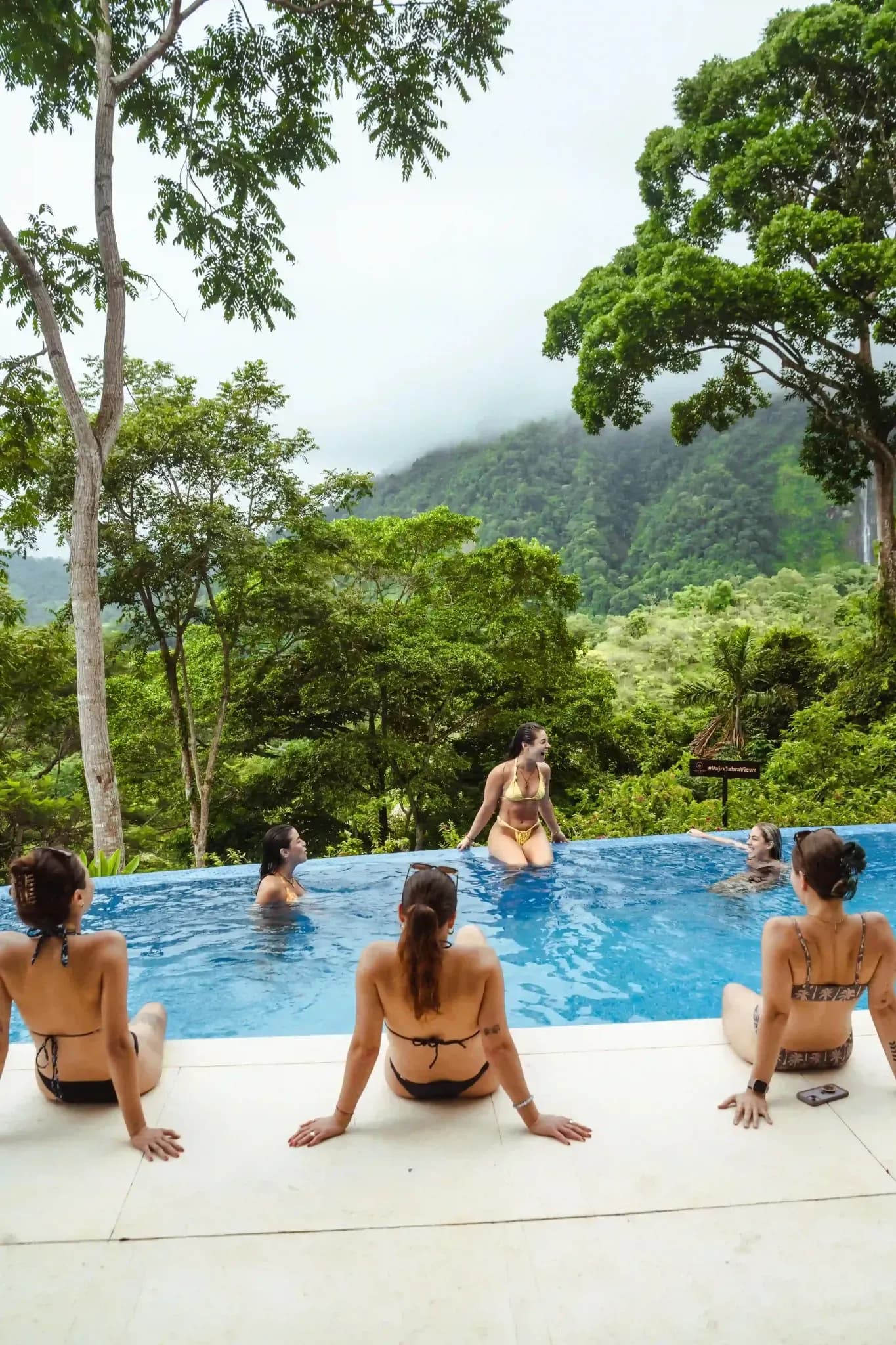 Guests unwinding by the infinity pool overlooking lush mountains at Vajra Jahra Retreat Center, an inspiring Corporate Retreat Venue in Costa Rica.