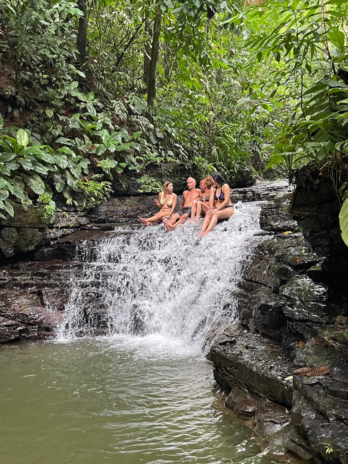 Vajra Jahra retreat guests enjoying casual conversation sitting on a waterfall in Costa Rica