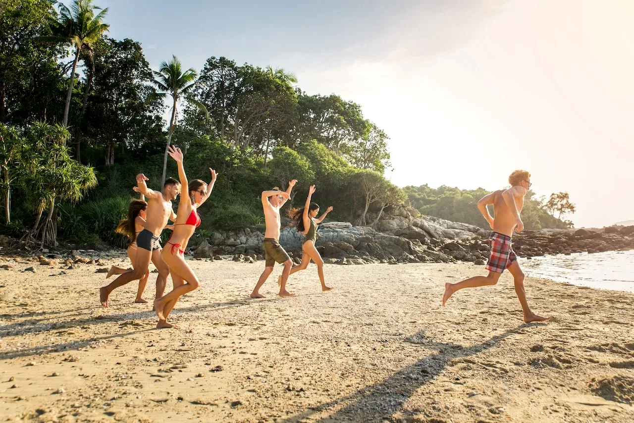Group running down the beach into the ocean on a leadership retreat.