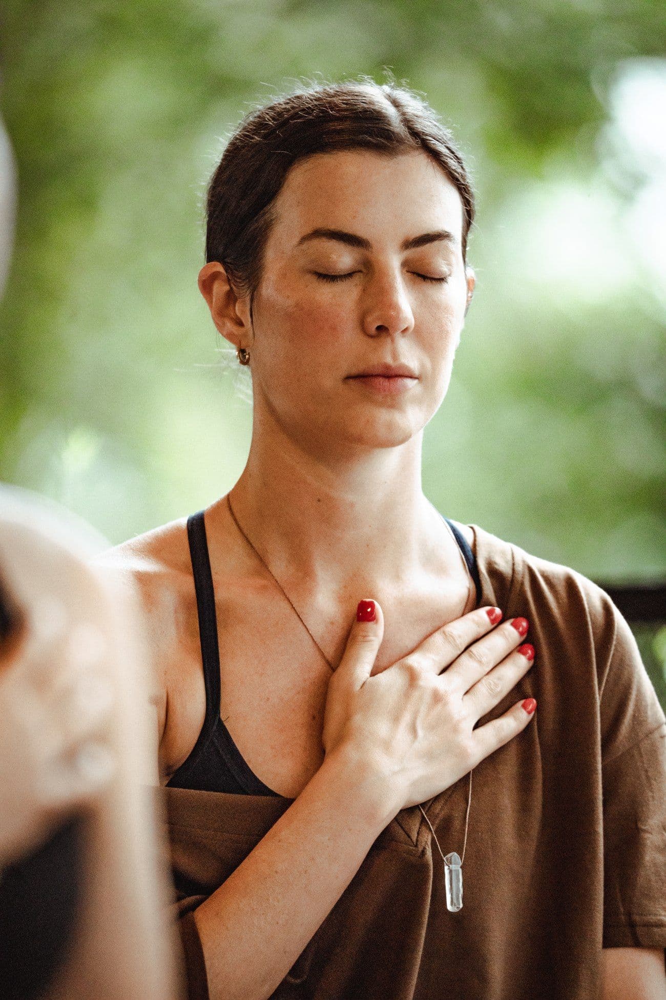 Girl meditating in silence in nature at a mindful retreat.