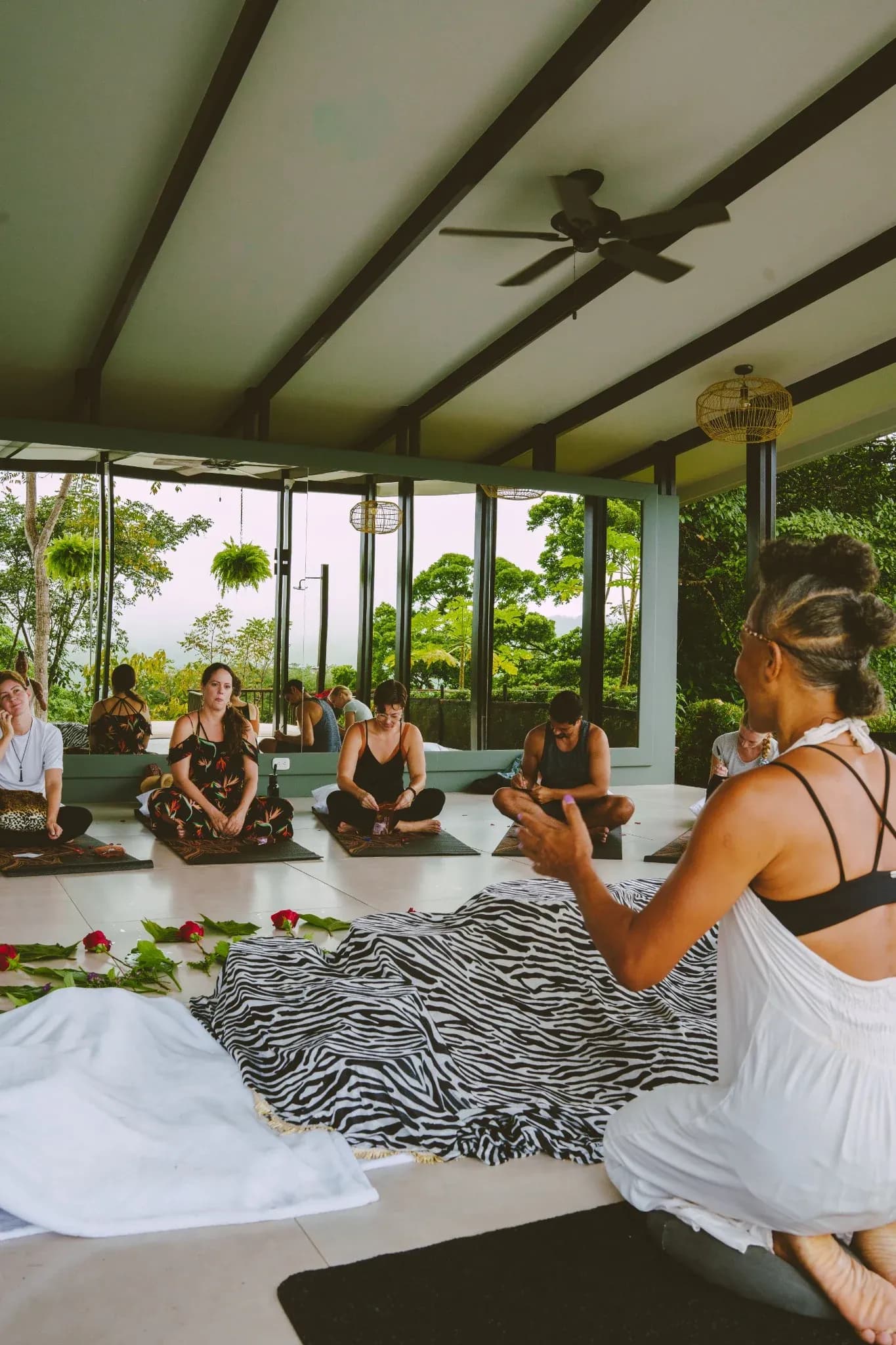 A wellness instructor guides a mindful group meditation at the open-air pavilion of Vajra Jahra Retreat Center, creating an inspiring environment ideal for those seeking a Costa Rica Yoga Teacher Training experience.