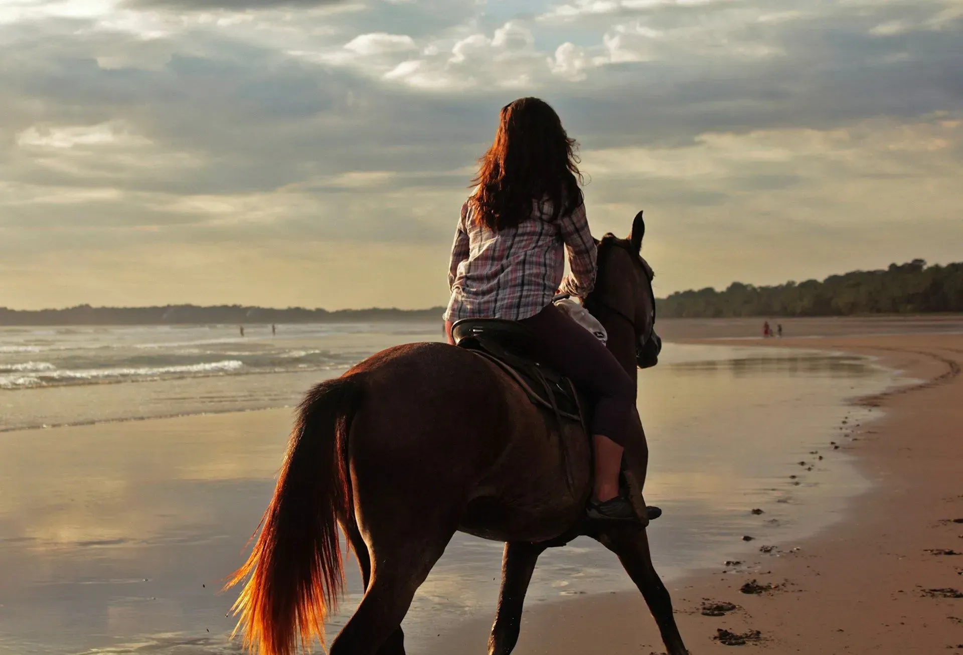Person horseback riding along a serene Costa Rica beach at sunset near Vajra Jahra Retreat Center, offering a peaceful excursion option for Costa Rica Yoga Teacher Training guests.