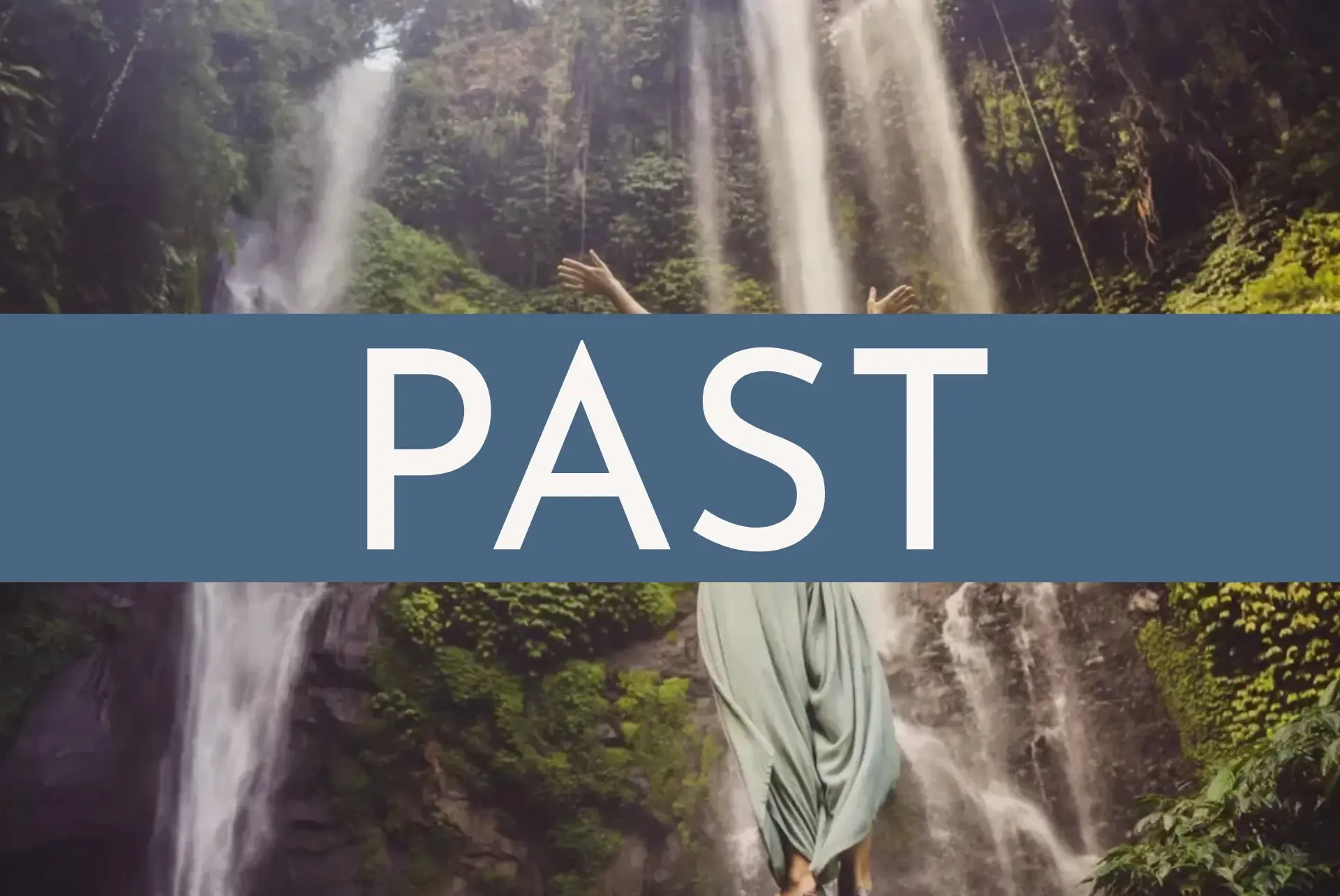 Woman raising her arms before a majestic waterfall surrounded by lush forest during a retreat Costa Rica experience at Vajra Jahra Retreat Center.