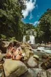 Guests relaxing by a waterfall during a hike near Vajra Jahra Retreat Center in Costa Rica.