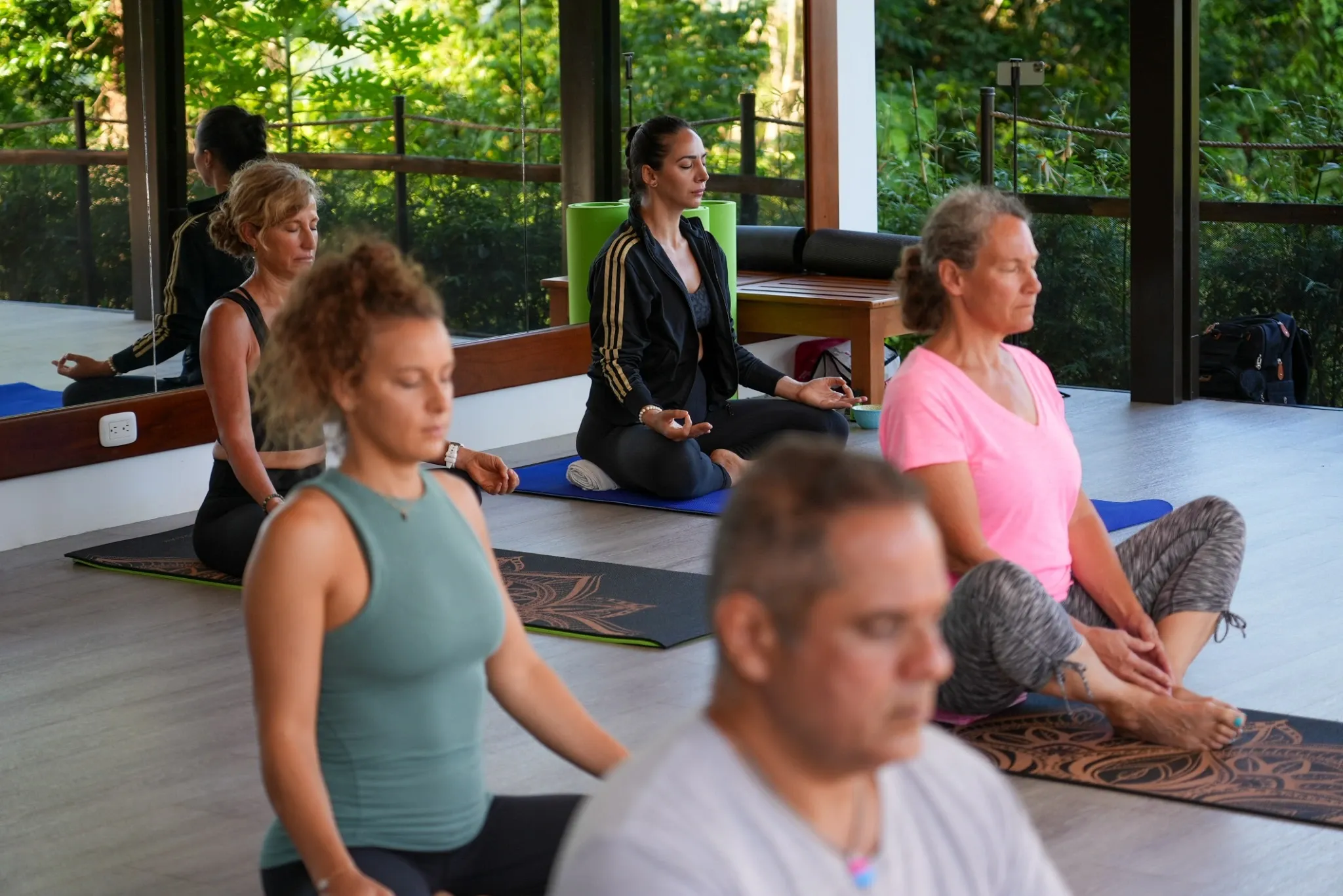 Yogis in an open air shala performing the lotus pose, which has a history going back to the very origin of yoga.